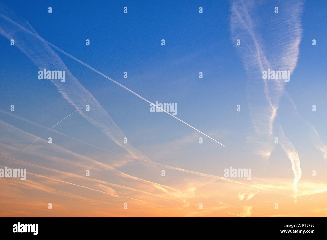 Bandes de code dans le ciel au-dessus de Schleswig au coucher du soleil en début de soirée à la fin de l'hiver. Dans les théories du complot, ces nuages légers causés par les avions sont également appelées chemtrails. Chemtrails est la contraction de l'anglais pour les produits chimiques et produits chimiques pour les traînées traînées, en allemand pour des bandes de produits chimiques. Dans le monde d'utilisation | Banque D'Images