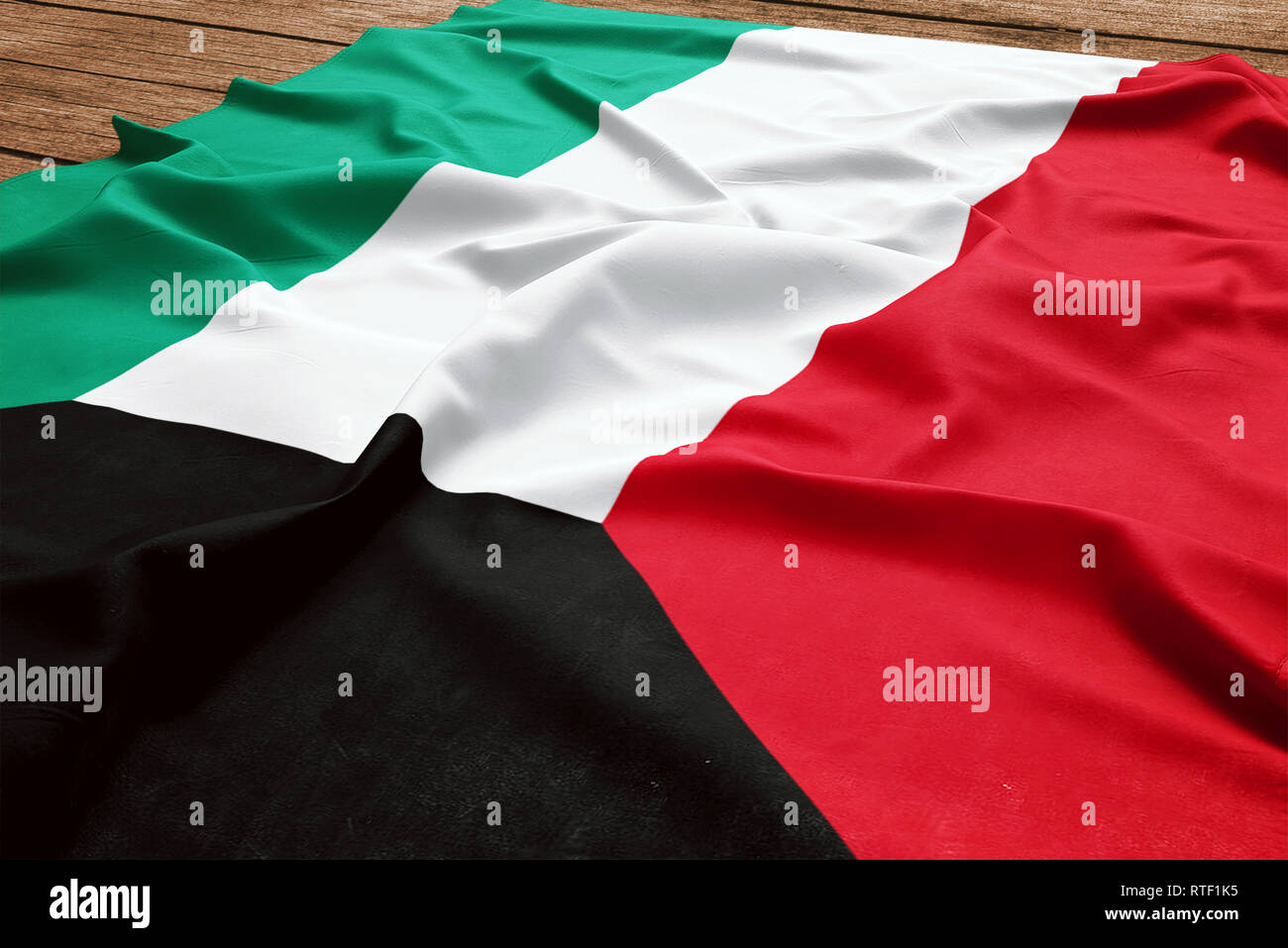 Pavillon du Koweït sur un bureau en bois. Drapeau koweïtien soie vue d'en haut. Banque D'Images