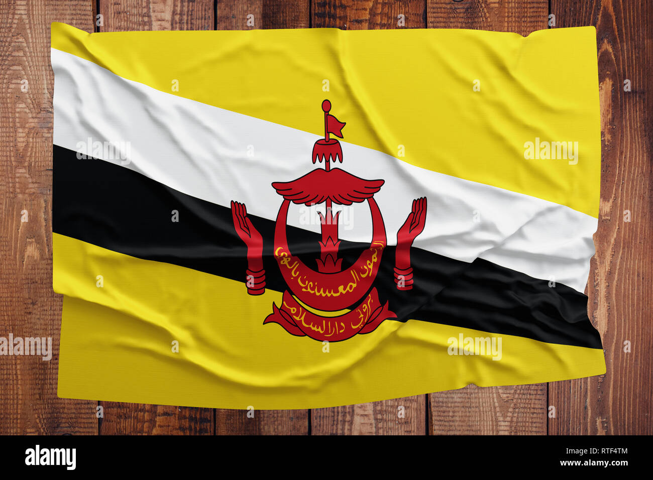 Pavillon de Brunéi sur une table en bois. Brunéien froissé drapeau haut vue. Banque D'Images