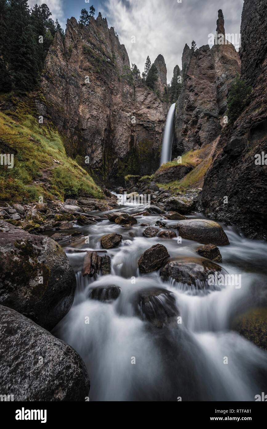 Cascade s'écoule à travers le paysage érodé avec aiguilles de roche, Tour Tour de l'automne avec Creek, Parc National de Yellowstone, Wyoming, USA Banque D'Images
