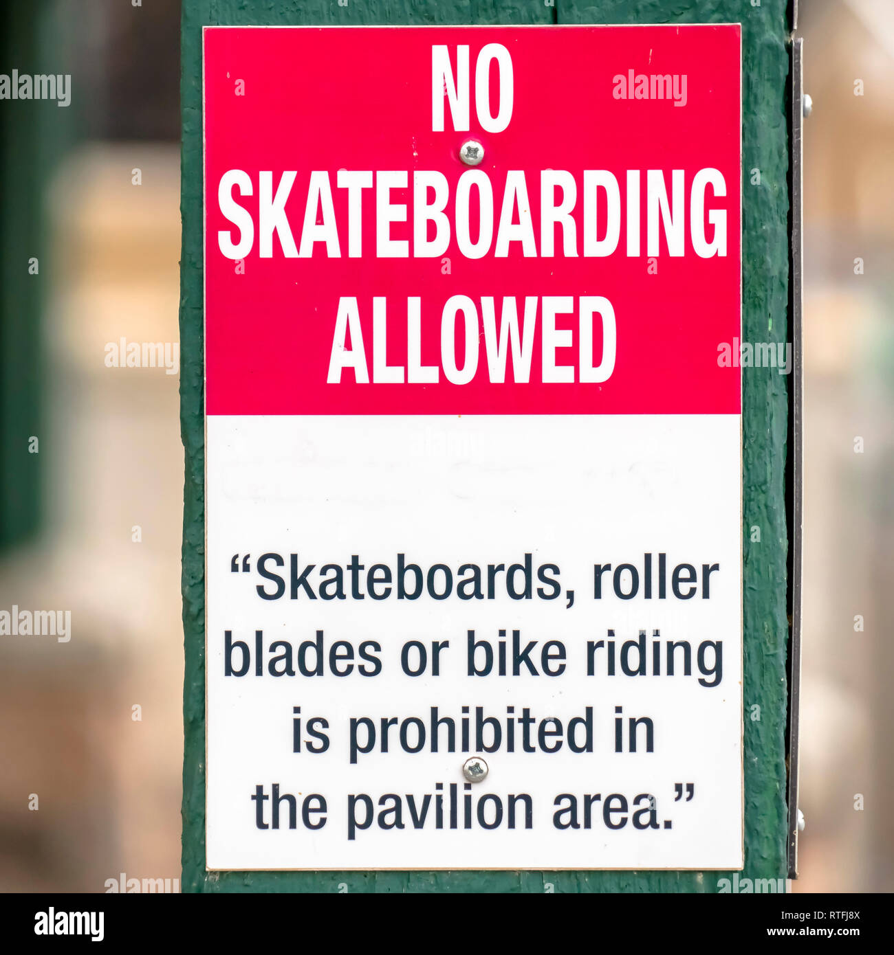 Pas de planche à roulettes admis dans le pavillon area. Pas de planche à roulettes admis dans le pavillon salon signe sur un poste en bois vert. L'interdiction : Banque D'Images