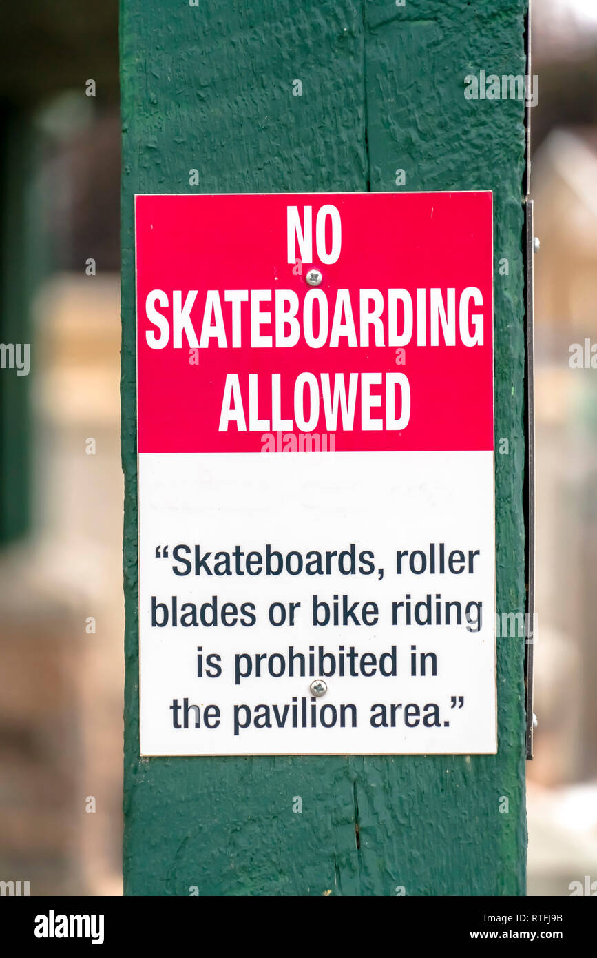Pas de planche à roulettes admis signe sur un poste en bois. Pas de planche à roulettes admis signe sur un poste en bois. Il informe les gens que les planches à roulettes, patins à roues alignées, et Banque D'Images