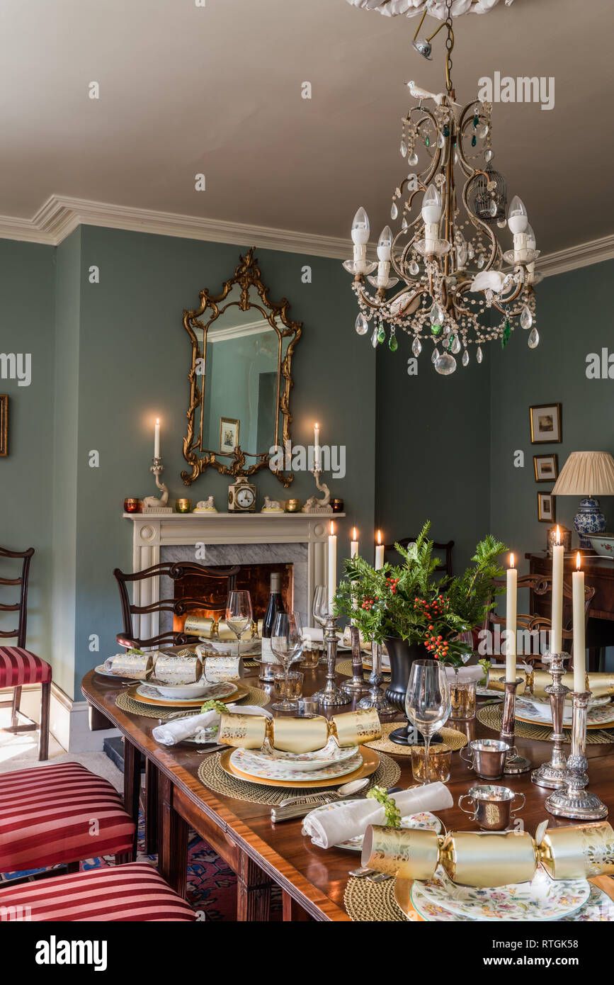 Table à manger en acajou avec des chaises capitonnées de Regency stripe avec cheminée en anglais Banque D'Images