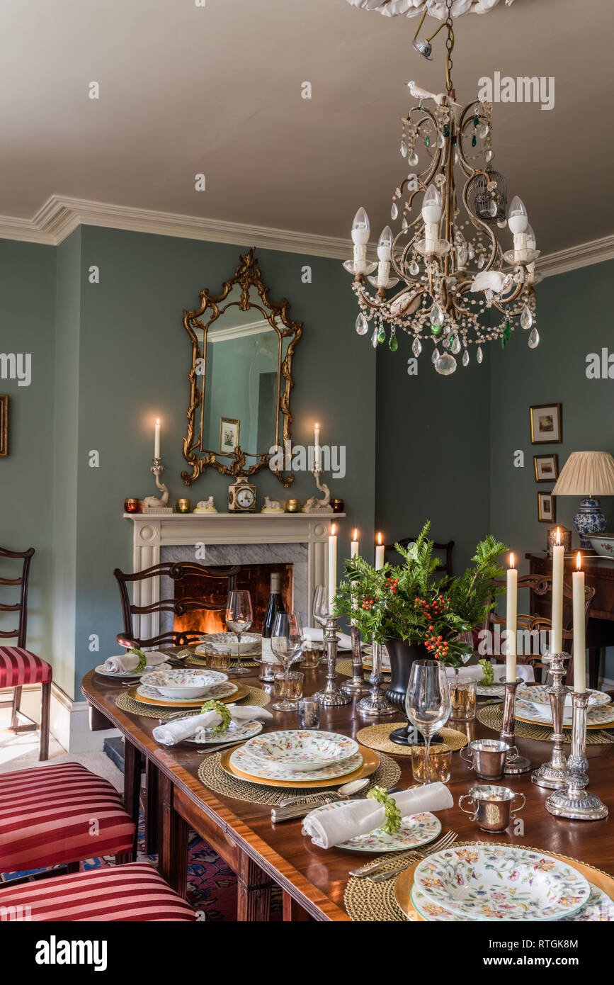 Table à manger en acajou avec des chaises capitonnées de Regency stripe avec cheminée en anglais Banque D'Images