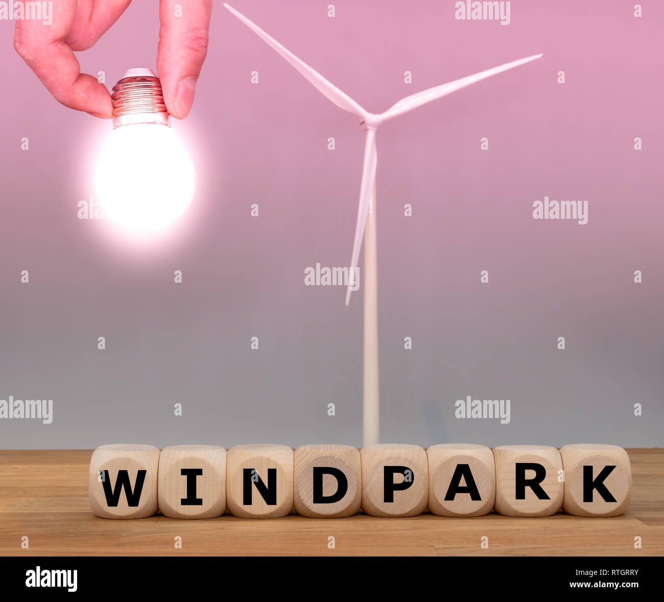 Symbole de l'énergie verte. Formulaire dés le mot 'wind park' en face d'un modèle d'éolienne et une ampoule. Banque D'Images