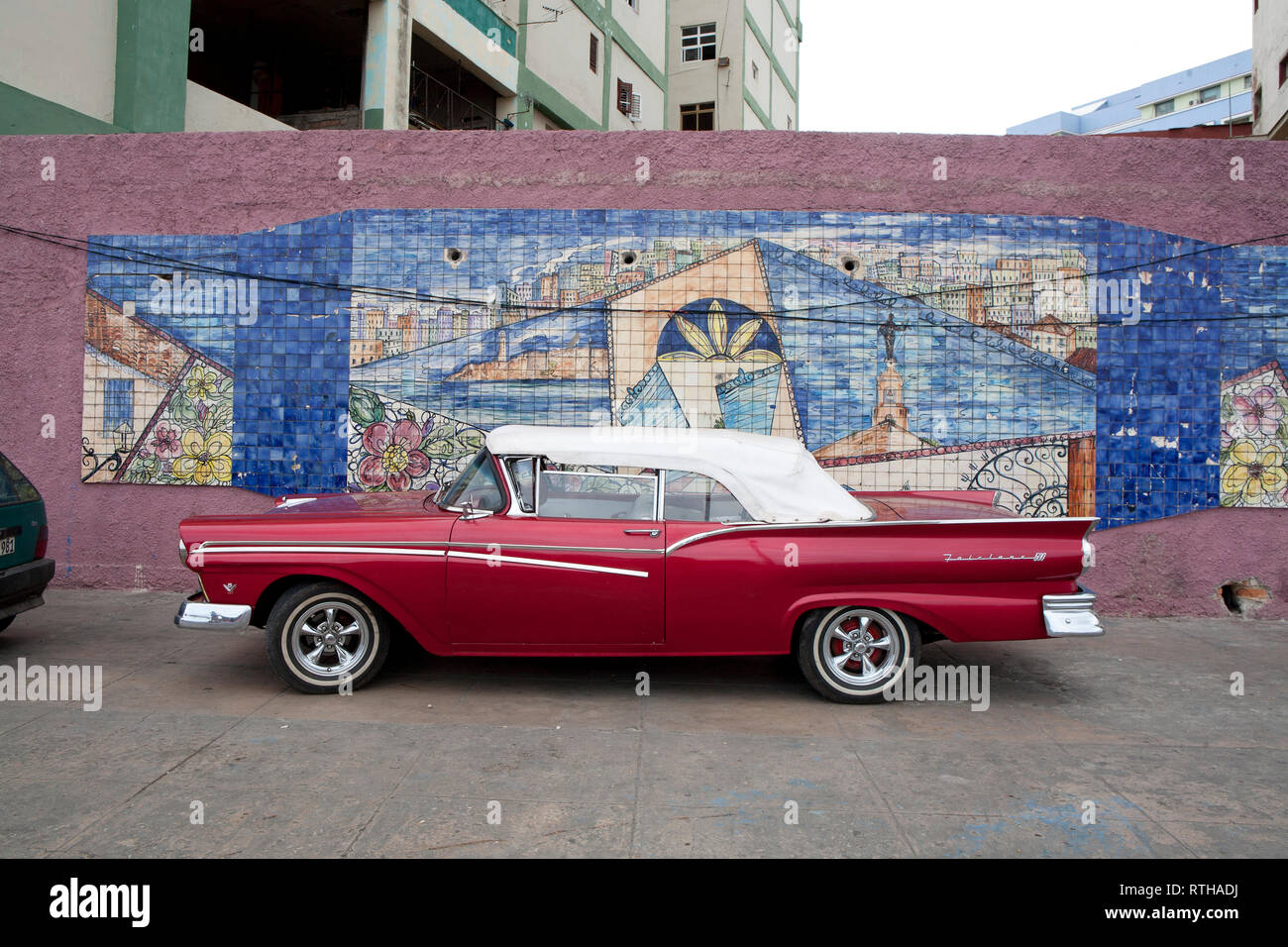 Classic 1960 voiture américaine garée contre un mur coloré à Cuba avec 60 bâtiments de distance Banque D'Images