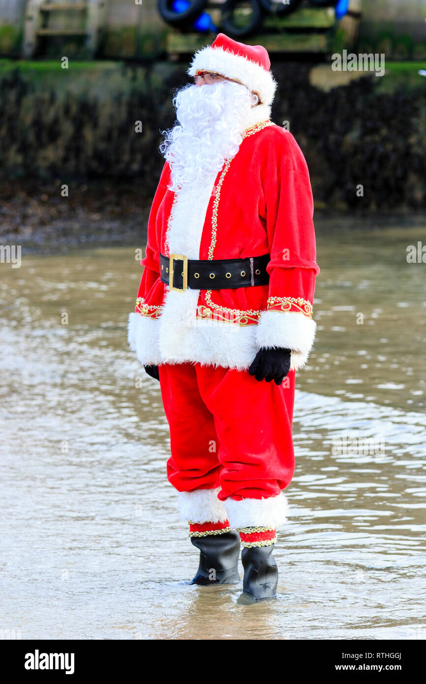 Homme habillé en père Noël avec une longue barbe blanche fake, debout