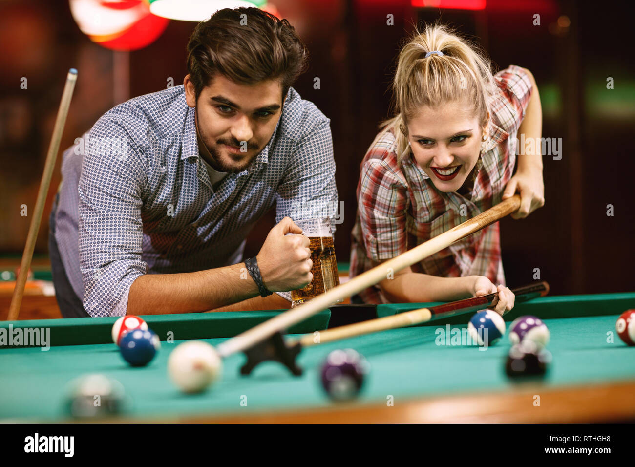 Beau couple heureux de jouer au billard dans un pub Banque D'Images