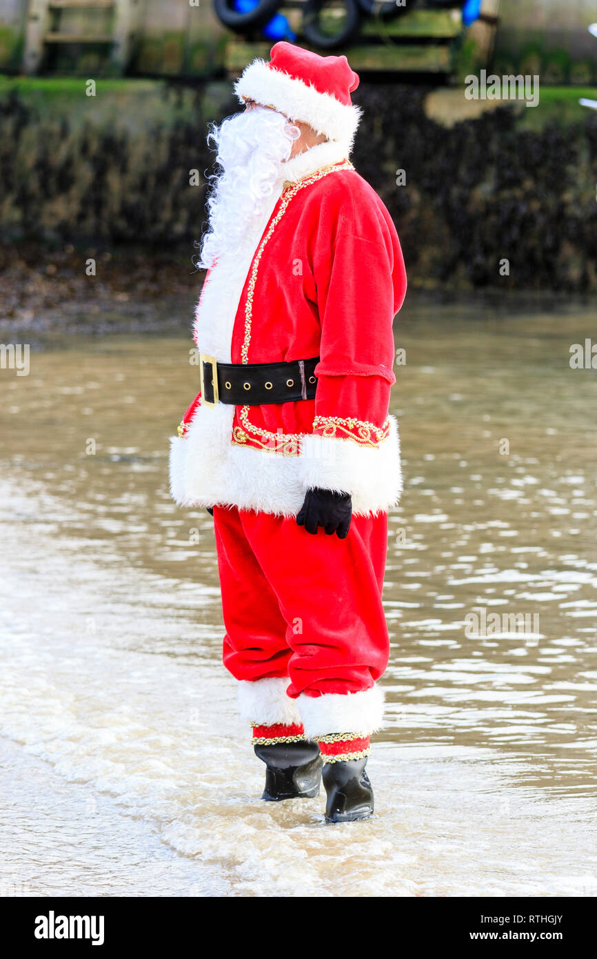 Homme habillé en père Noël avec une longue barbe blanche fake, debout