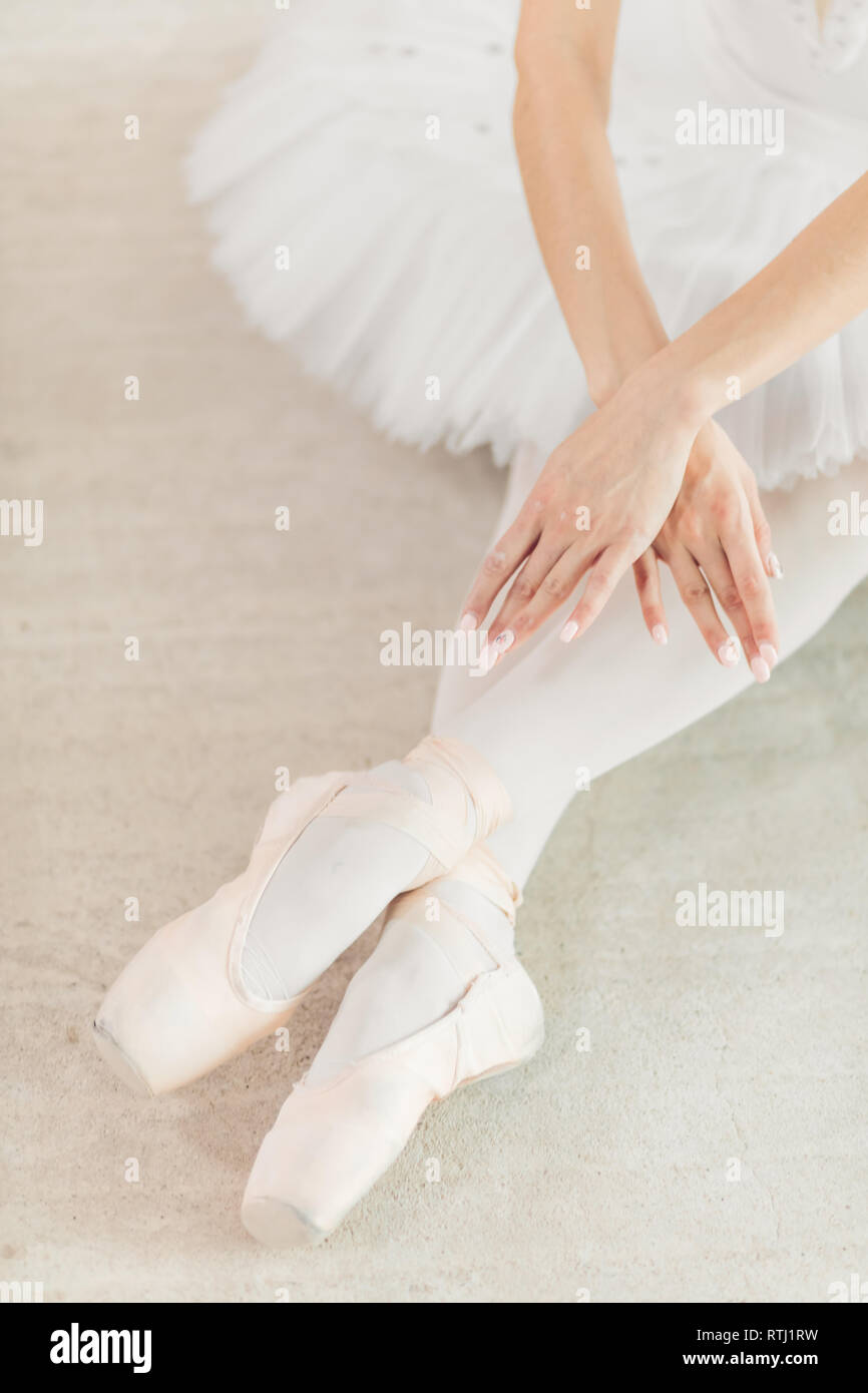 Danseuse assise sur le sol avec les jambes croisées. close up photo recadrée, position finale de la performance, Swan Lake Banque D'Images