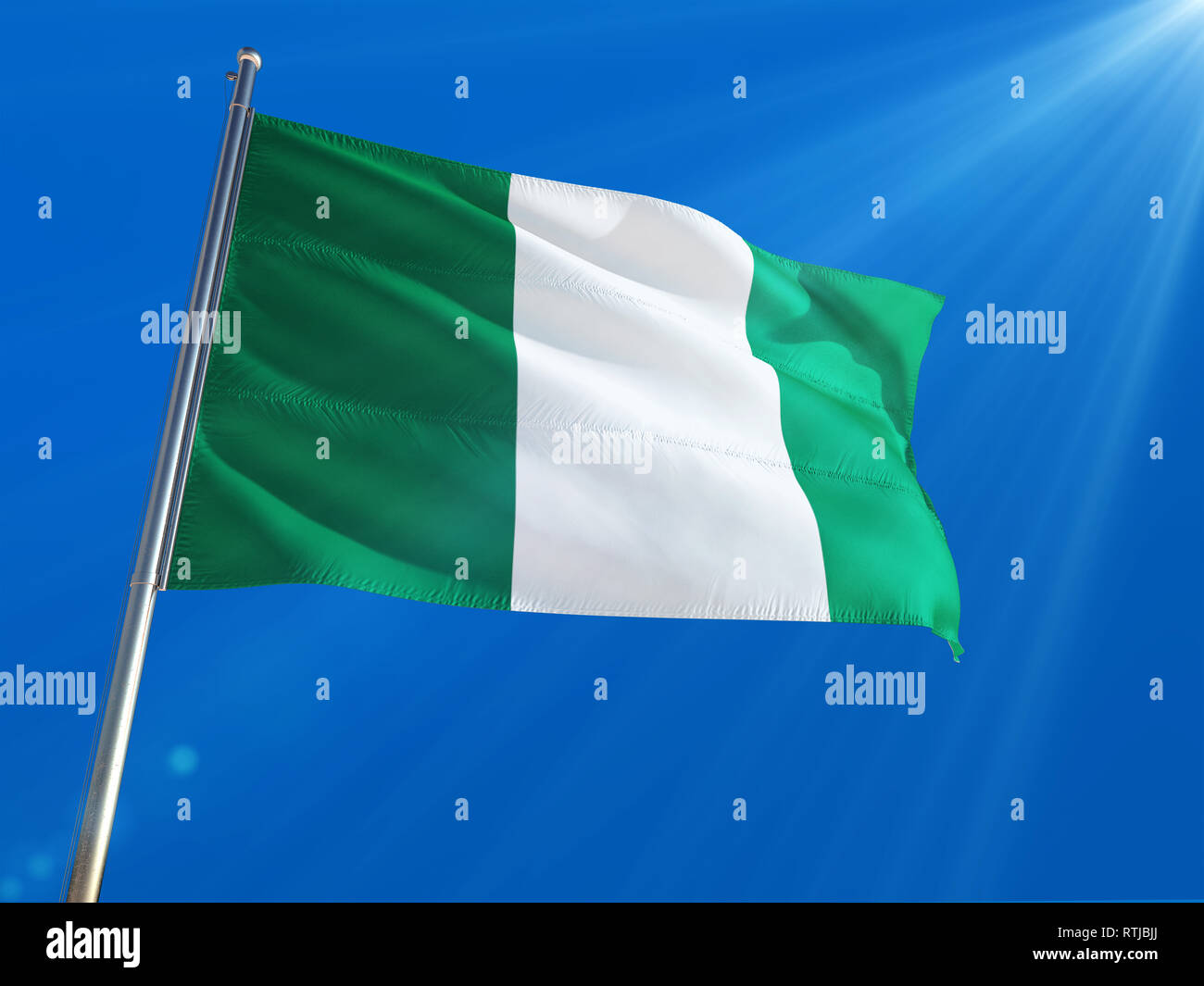 Le Nigeria de brandir le drapeau national sur le poteau contre Deep blue sky background. La Haute Définition Banque D'Images
