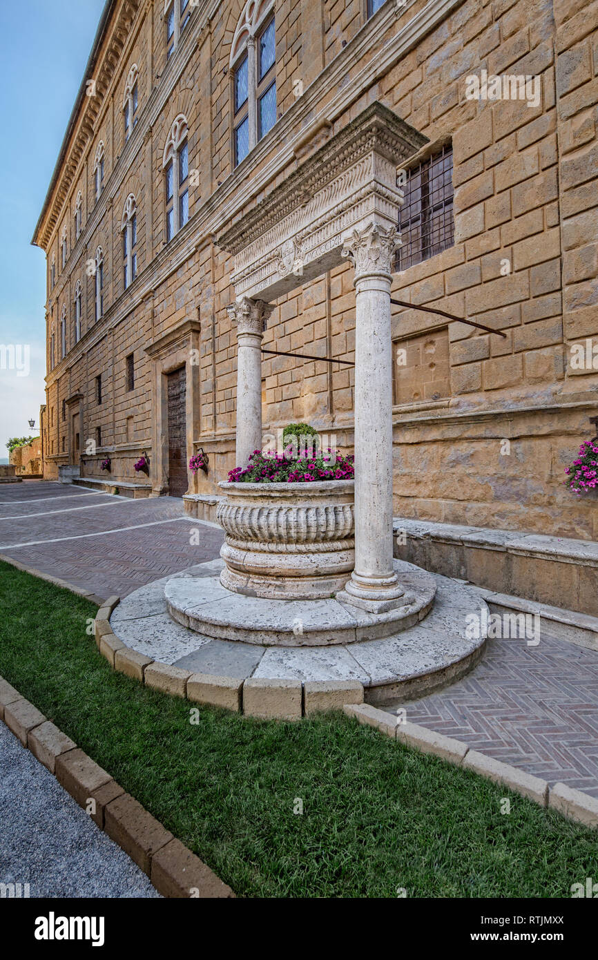 Vieux puits sur la place principale de Pienza. Le travertin et de l'Rossellino et l'avant du Palais Piccolomini à Pienza, Toscane, Italie Banque D'Images