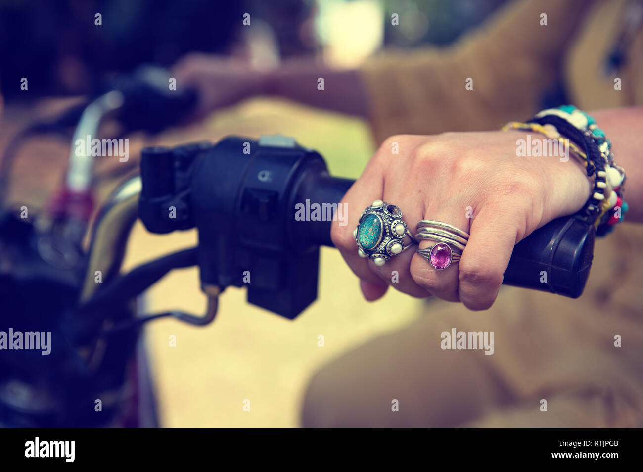 Women's Hands close-up avec des bijoux sur le guidon d'une moto Banque D'Images
