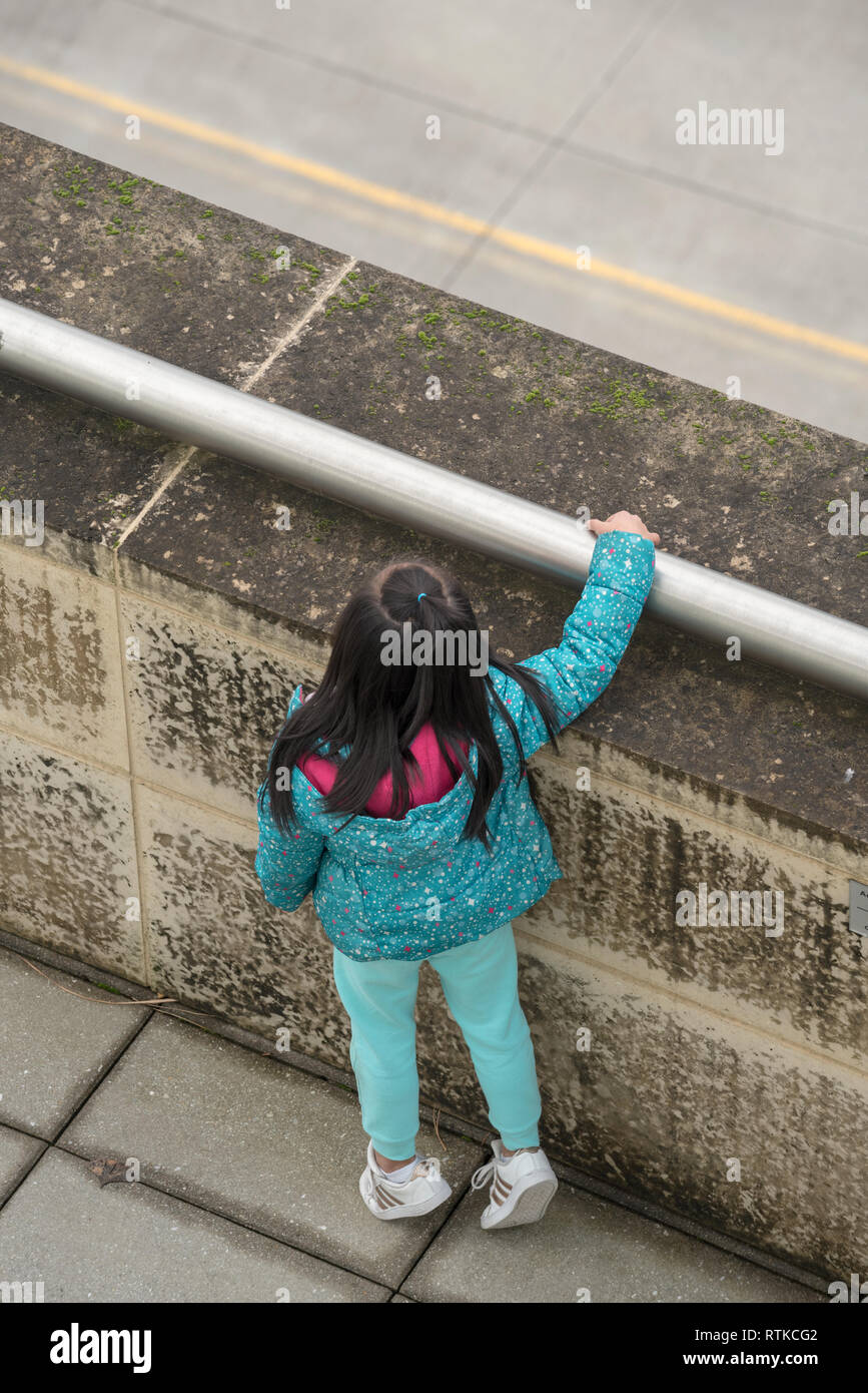 Girl looking over wall, Portland, Oregon. Banque D'Images
