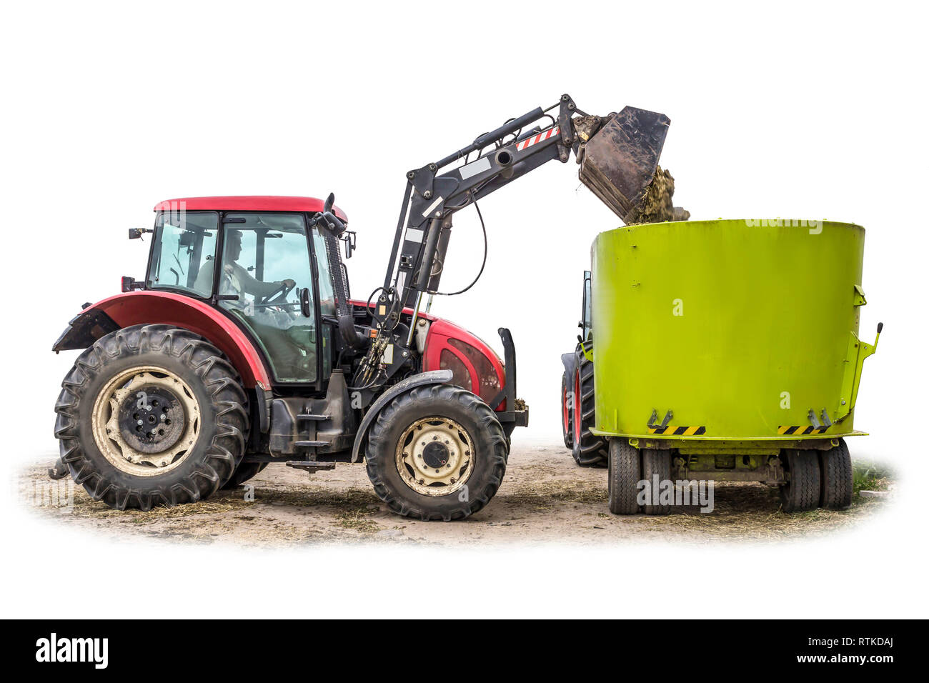 Un tracteur avec chargeur frontal, la charge d'alimentation de l'ensilage dans un distributeur d'aliments pour animaux. Isolé photo. Équipement nécessaire pour une exploitation laitière. Banque D'Images