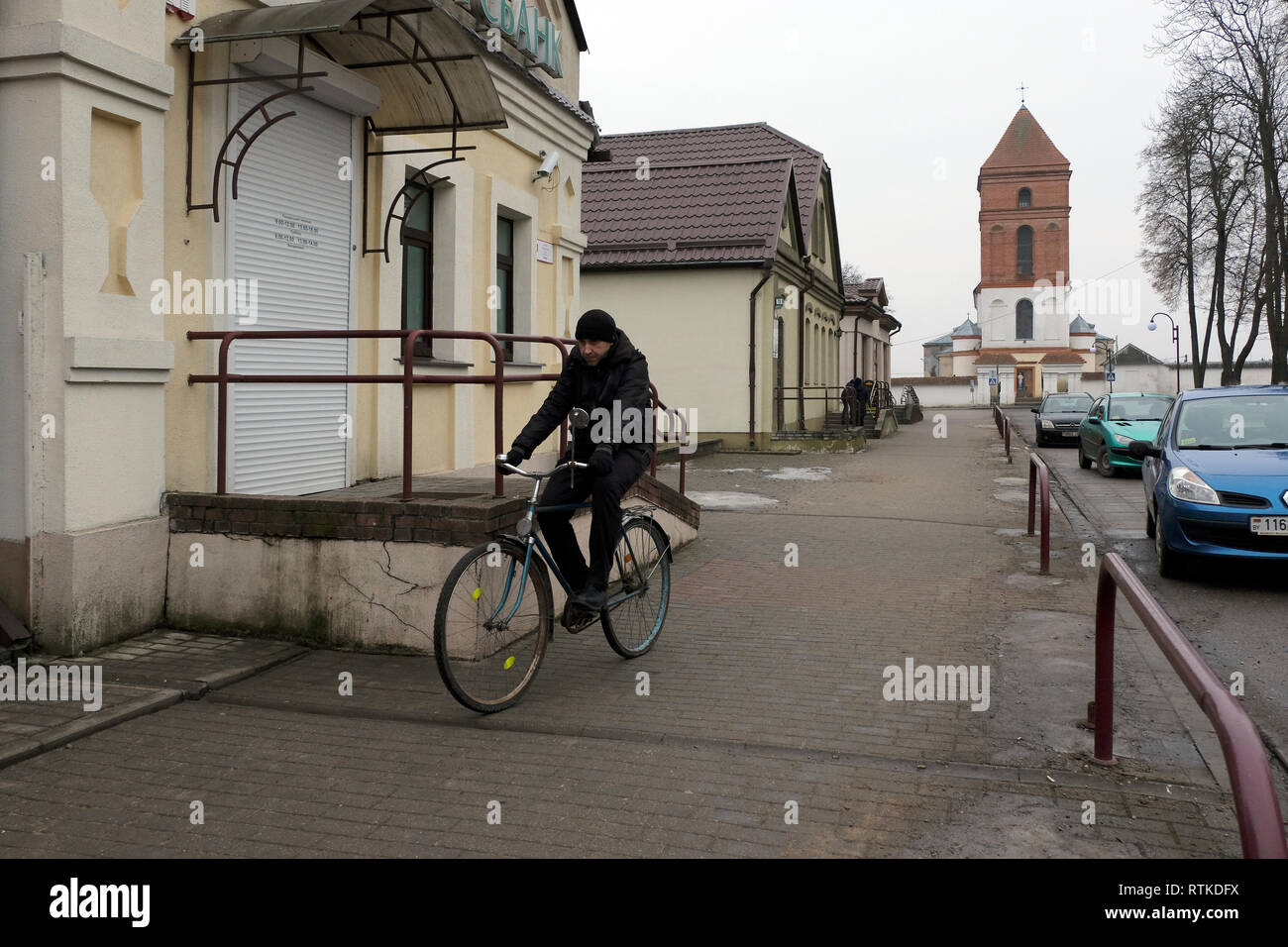 Un homme qui monte à vélo dans la ville de Mir dans le district de Karelcy de la voblast de Hrodna, Biélorussie Banque D'Images