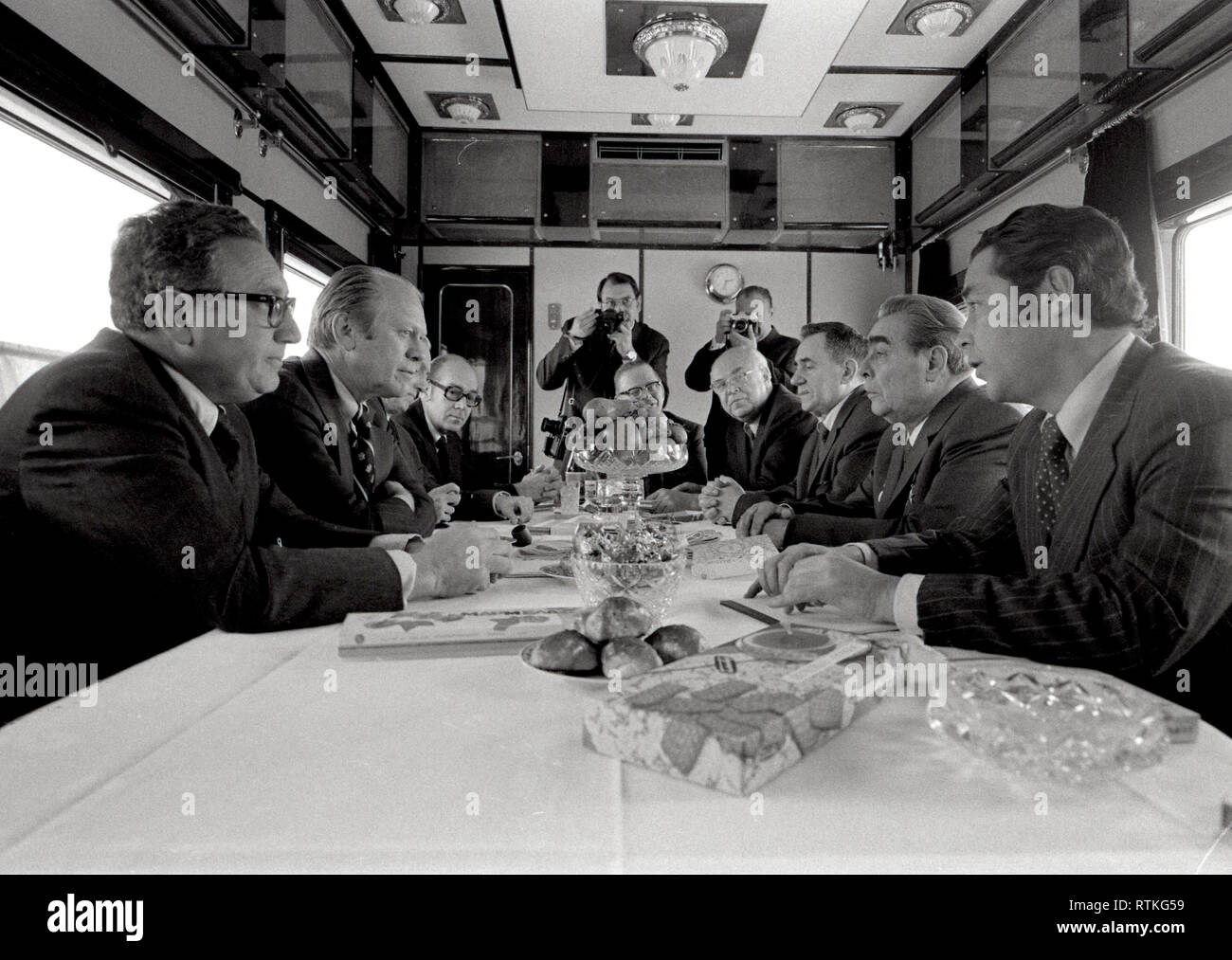 1974, 23 Novembre - Train soviétique - Union des Républiques socialistes soviétiques - Gerald R. Ford, Henry Kissinger, Helmut Sonnenfeldt, l'Ambassadeur Walter J. Stoessel, Leonid Brejnev, Andrei Gromyko, l'Ambassadeur Anatoly Dobrynin, Victor Sukhrodev ; d'autres dans les contingents américains et soviétiques - assis autour de la table, de parler - Voyage à l'Union des Républiques socialistes soviétiques (URSS) - réunion au cours de trajet en train pour Vladivostok - (heure locale) ; Stoessel (Ambassadeur des Etats-Unis à l'URSS) ; Brejnev (Secrétaire général de l'URSS) ; Gromyko (Ministre des affaires étrangères de l'URSS) ; Dobrynin (URSS L'ambassadeur à t Banque D'Images