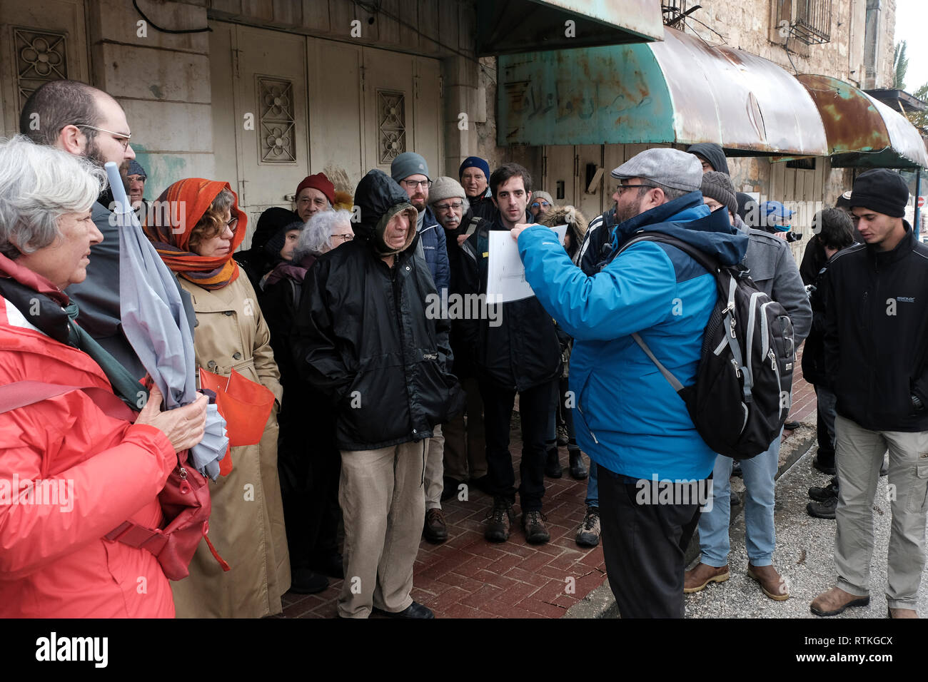 Yehuda Shaul, fondateur de Breaking the Silence, parle à un groupe d'Israéliens devant un passage bloqué dans la rue Al-Shuhada qui était autrefois le marché de gros central de la région d'Hébron et a été fermé aux marchands palestiniens après la violence dans la deuxième Intifada de la vieille ville d'Hébron Cisjordanie Israël. Breaking the Silence (BTS) est une organisation non gouvernementale israélienne créée en 2004 par d'anciens soldats israéliens engagés à dénoncer les violations des droits de l'homme commises par l'armée israélienne dans les territoires occupés. Banque D'Images