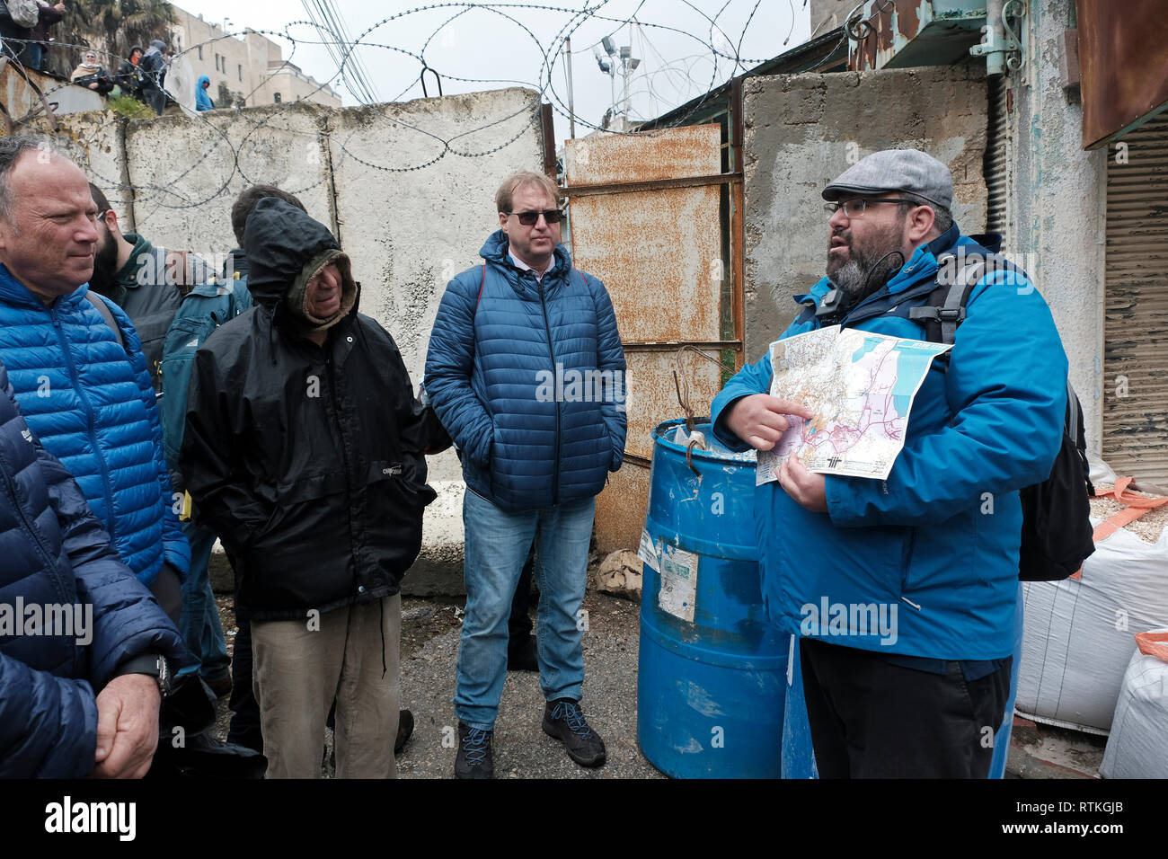 Yehuda Shaul, fondateur de Breaking the Silence, parle à un groupe d'Israéliens devant un passage bloqué dans la rue Al-Shuhada qui était autrefois le marché de gros central de la région d'Hébron et a été fermé aux marchands palestiniens après la violence dans la deuxième Intifada de la vieille ville d'Hébron Cisjordanie Israël. Breaking the Silence (BTS) est une organisation non gouvernementale israélienne créée en 2004 par d'anciens soldats israéliens engagés à dénoncer les violations des droits de l'homme commises par l'armée israélienne dans les territoires occupés. Banque D'Images