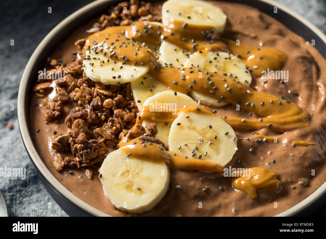 Smoothie au chocolat maison bol avec du beurre d'arachide et banane Banque D'Images