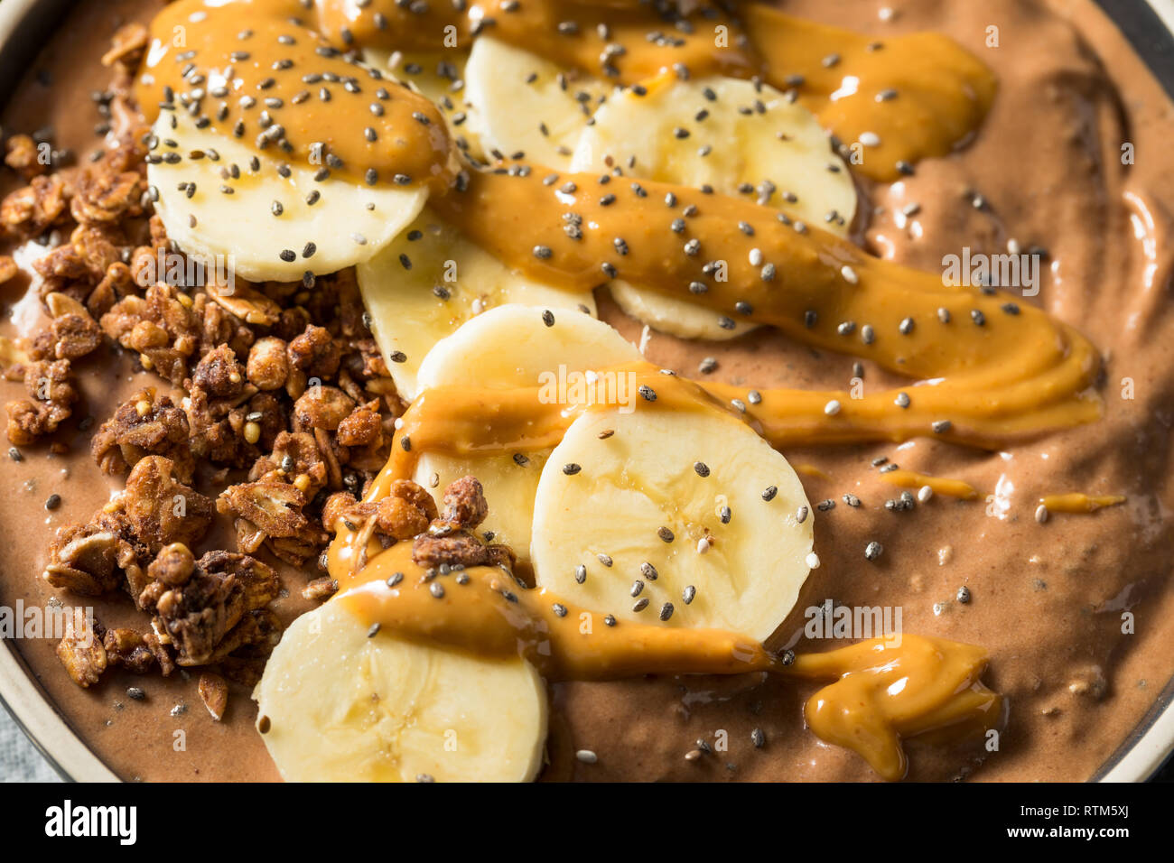 Smoothie au chocolat maison bol avec du beurre d'arachide et banane Banque D'Images