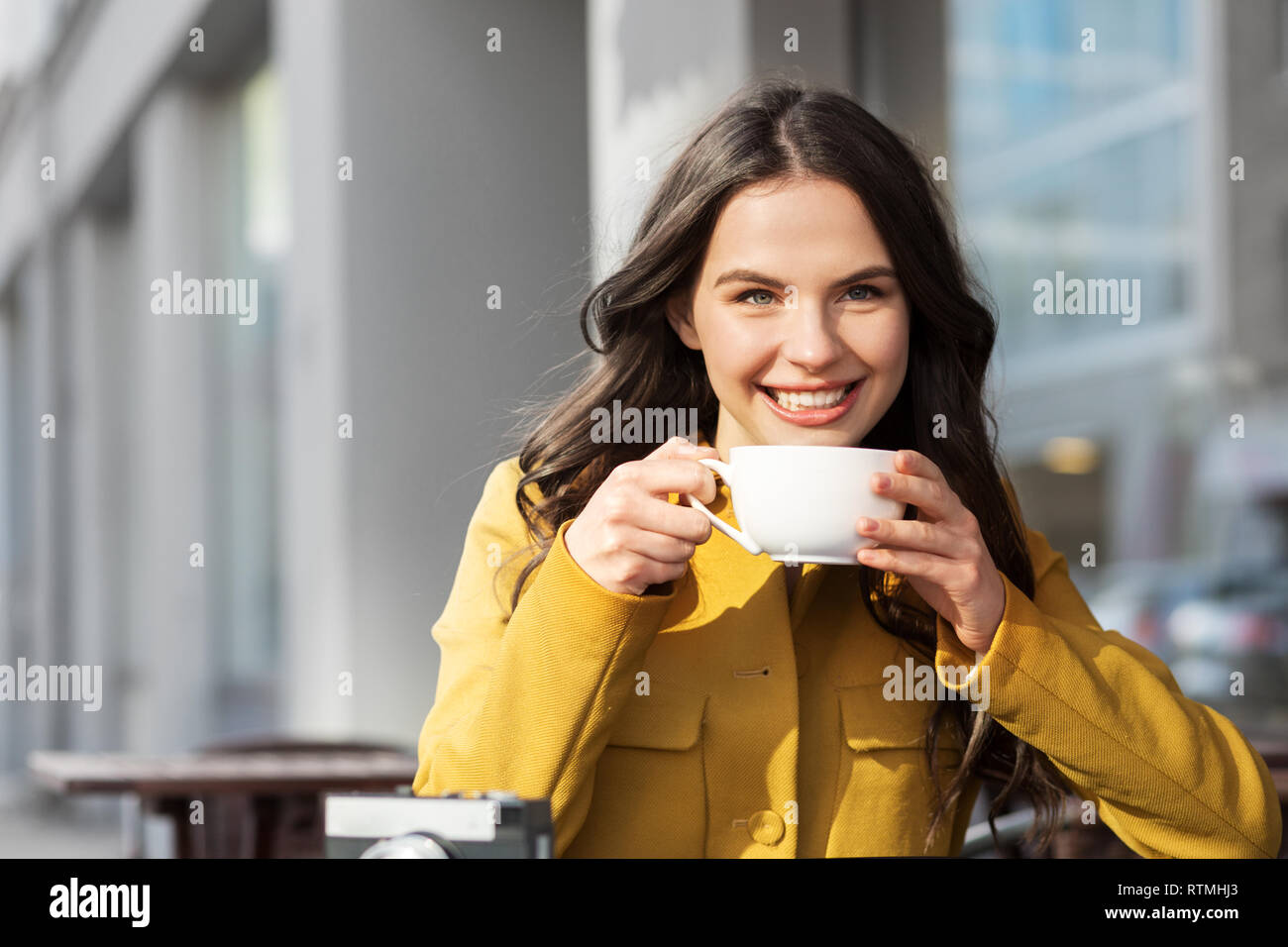 Teenage girl drinking hot chocolate au city cafe Banque D'Images