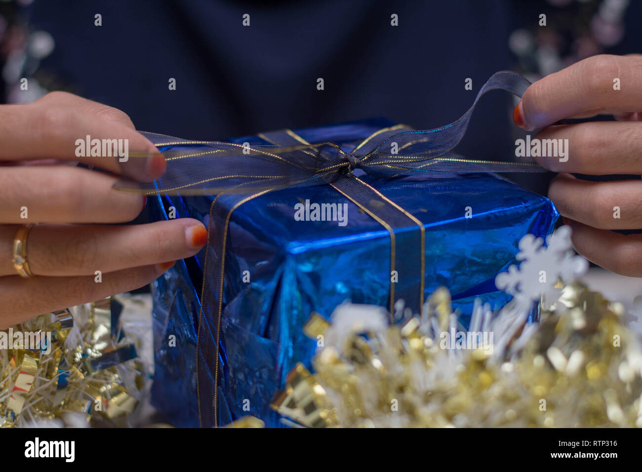 Close up femme main mains wrapping christmas gift, Close up, non préparé noël présente sur le tableau à l'intérieur de ciment accueil parc Banque D'Images