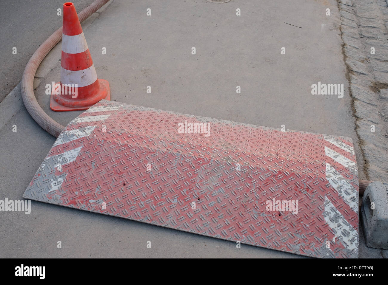 Feuille rouge canalisée avec voie guard sur trottoir at construction site Banque D'Images