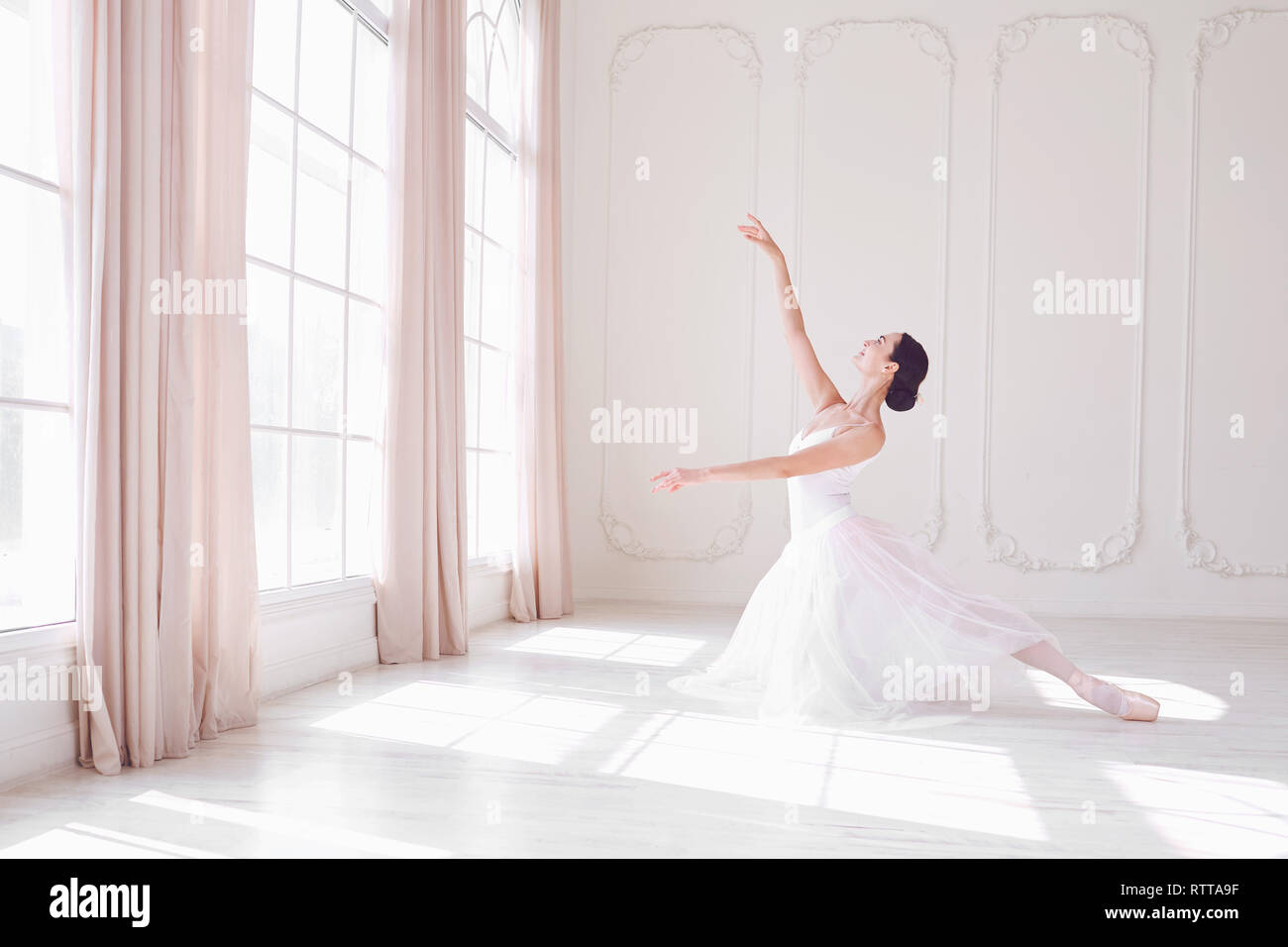 Young ballerina dancing in a white studio Banque D'Images