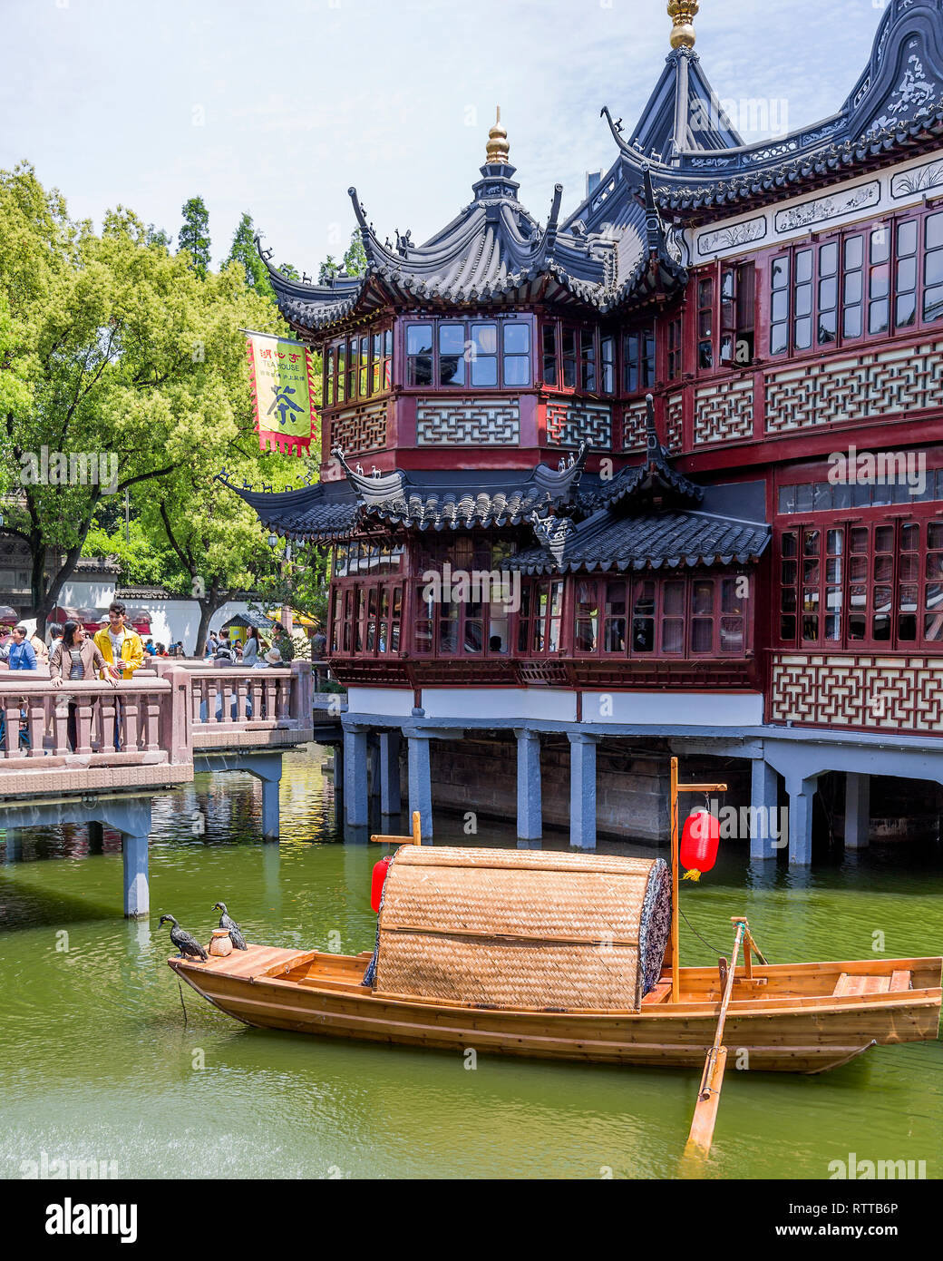 Maison de Thé Huxinting aka mi-salon de thé du pavillon du lac se dresse sur pilotis au milieu d'un lac artificiel. Un bateau de pêche chinois traditionnel à l'avant. Banque D'Images