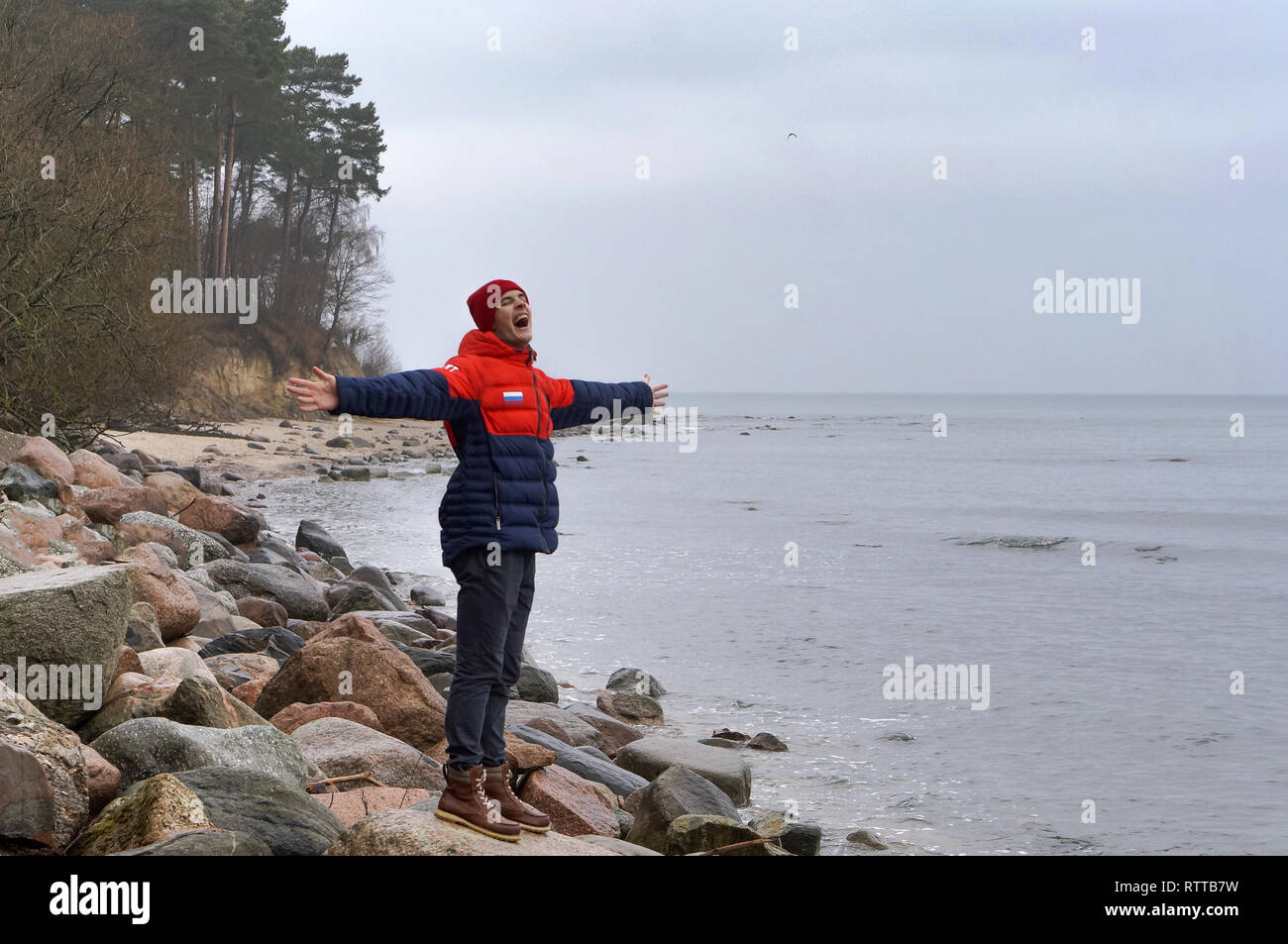 Jeune homme aime la mer, la pluie et le ciel couvert à mer, côte de la mer Baltique, la région de Kaliningrad, Russie, Décembre 30, 2018 Banque D'Images
