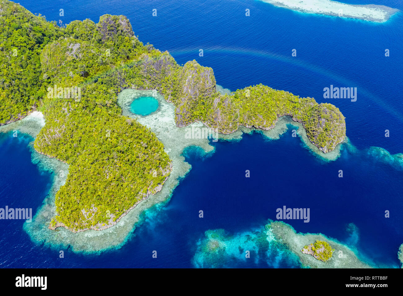 Vue aérienne d'un arc-en-ciel apparaît sur une série d'îles calcaires, Îles Raja Ampat, Papouasie occidentale, en Indonésie, l'Océan Pacifique Banque D'Images