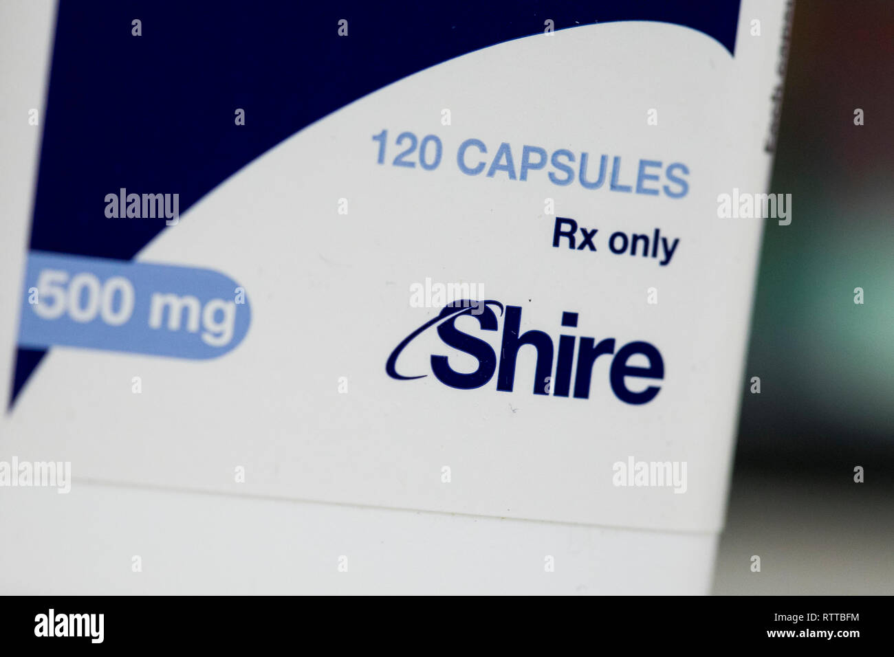Un logo de Shire est vu sur l'emballage de produits pharmaceutiques sur ordonnance photographié dans une pharmacie. Banque D'Images