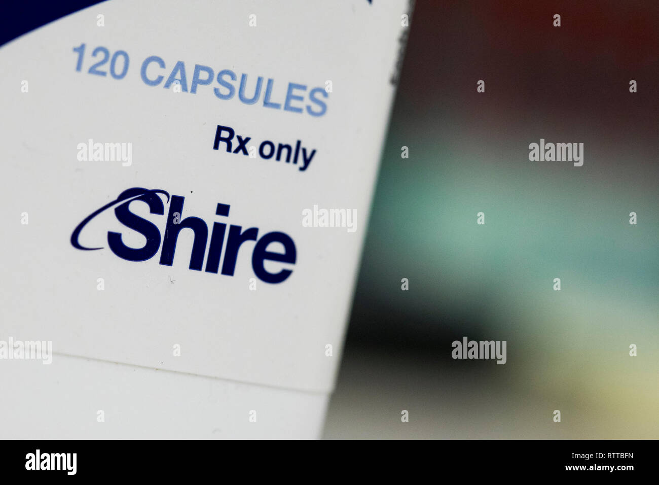 Un logo de Shire est vu sur l'emballage de produits pharmaceutiques sur ordonnance photographié dans une pharmacie. Banque D'Images