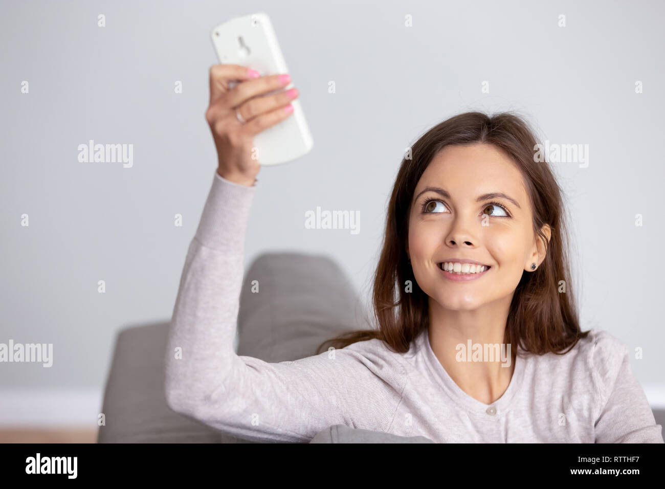 Jeune femme à l'aide de télécommande de climatiseur close up Banque D'Images