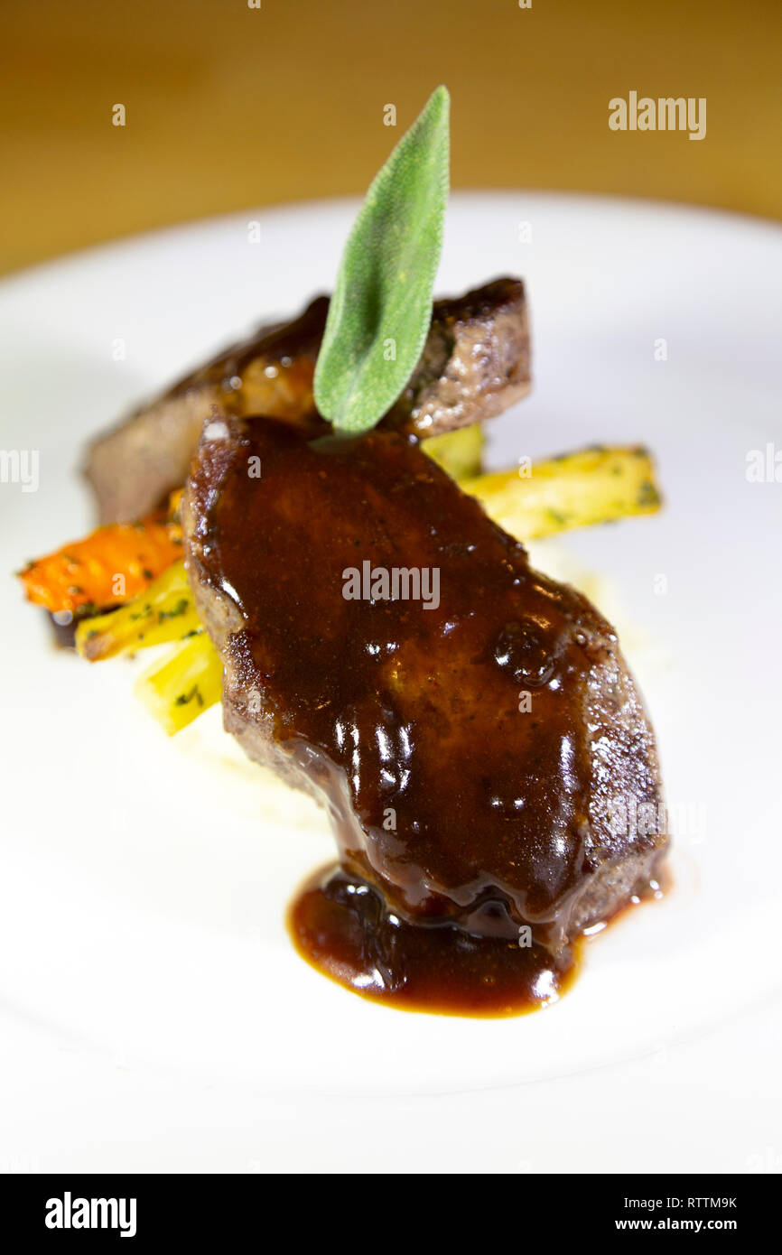 Steak recouvert d'un jus et servi dans les régions rurales du Manitoba, Canada. La viande est servi avec des légumes. Banque D'Images