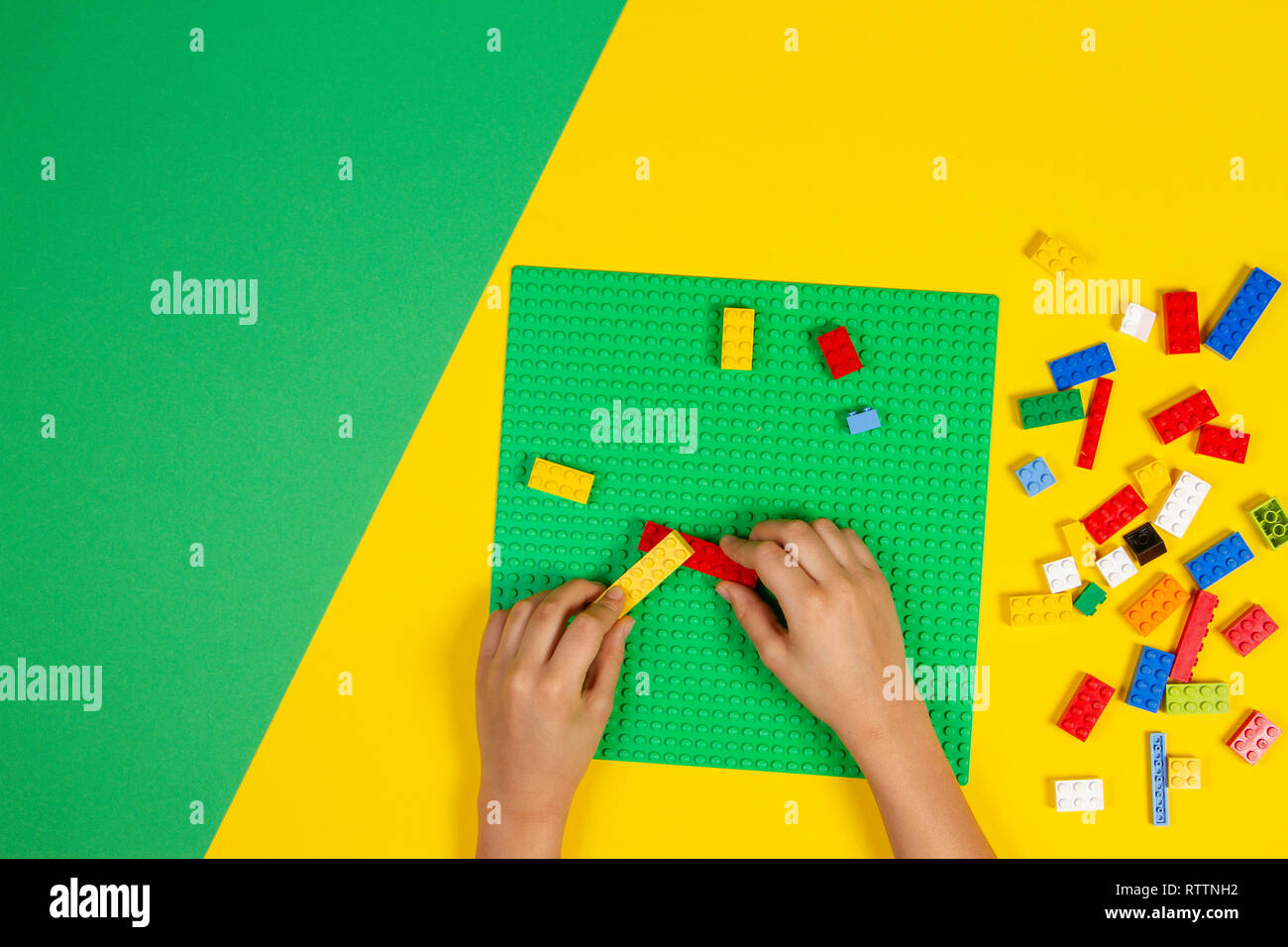 Les mains des enfants jouer avec des blocs Lego colorés sur la table Banque D'Images