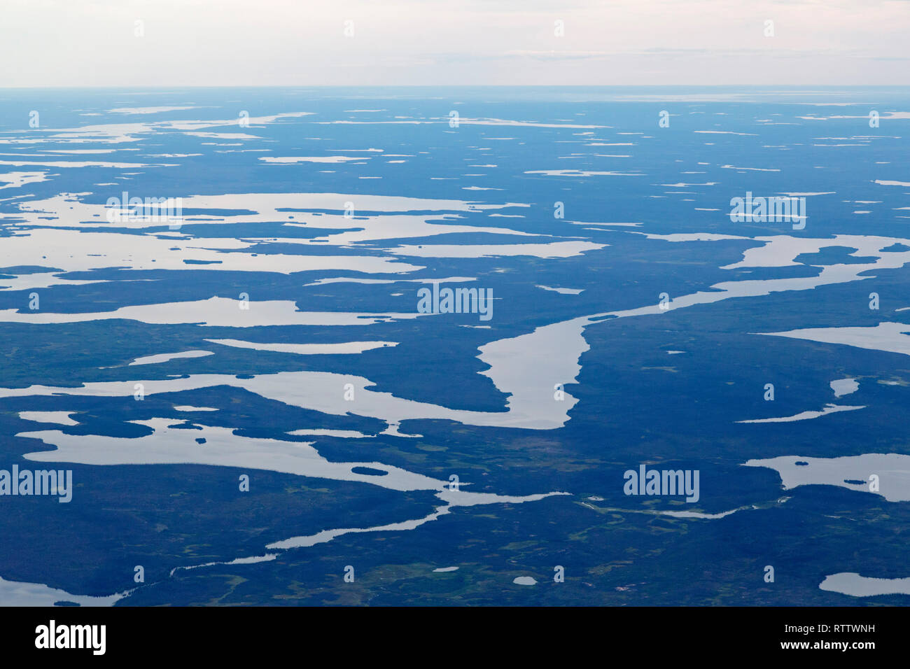 Un ciel couvert au-dessus du paysage plat au nord de Thompson au Manitoba, Canada. Le terrain est boisé et dispose de plans d'eau. Banque D'Images