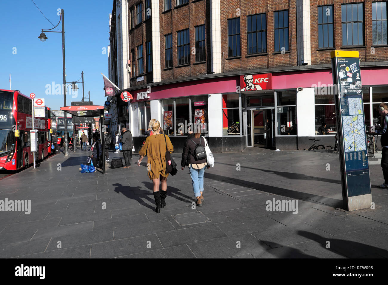 Vue arrière de la femme devant KFC Kentucky Fried Chicken restaurant sur Brixton Road à Brixton, quartier de Lambeth, dans le sud de Londres UK KATHY DEWITT Banque D'Images