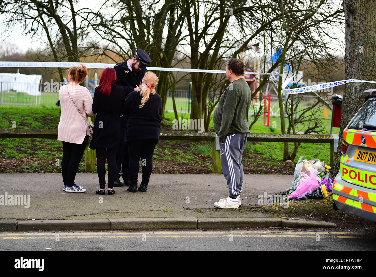 Les membres du public de parler à un agent de police près de la scène au St Neot's Road à Harold Hill, Londres est à la suite de la mort d'avoir poignardé une jeune fille de 17 ans le vendredi soir. Banque D'Images