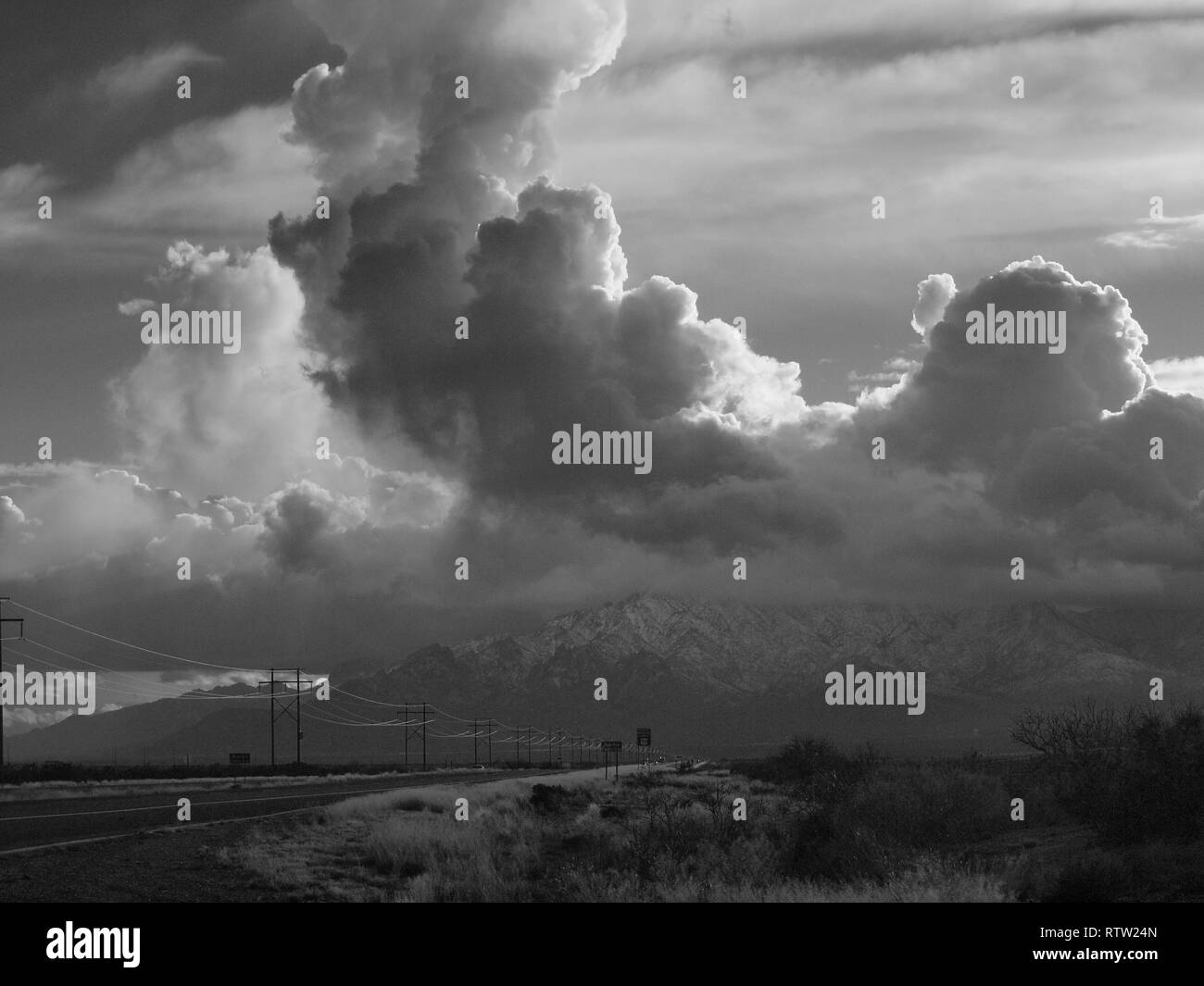 D'énormes nuages flottant au-dessus de nous 70 au Nouveau Mexique se dressant au dessus de la montagne en noir et blanc. Les lignes de marche vers l'horizon. Banque D'Images