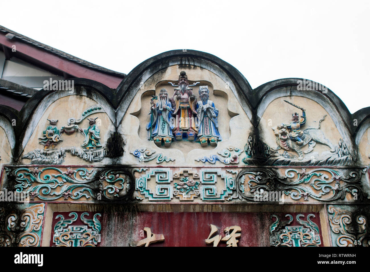 Vieux Mur Pignon avant traditionnelle d'un bâtiment à Chengdu avec Motif de décoration colorés et reliefs. Temple dieux comme décoration. Banque D'Images