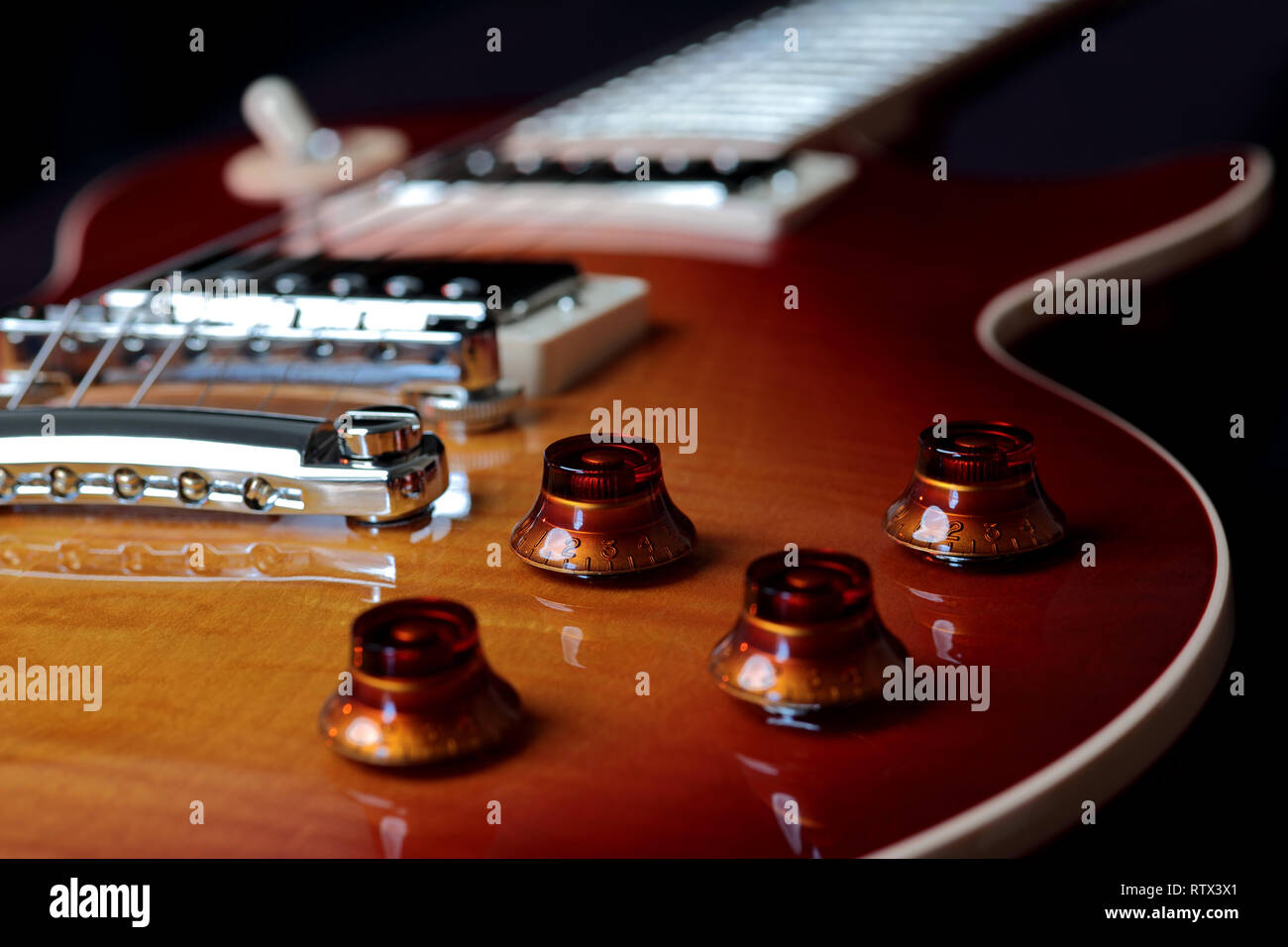 Close up de volume et de tonalité de la guitare électrique rouge cerise avec pont et cordes en arrière-plan Banque D'Images