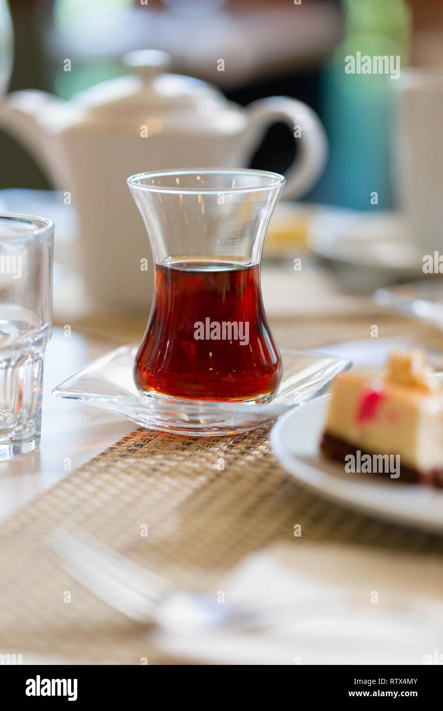 Du thé turc traditionnel en verre de forme sur la table dans un restaurant. Close up low angle shot à sun bright light Banque D'Images