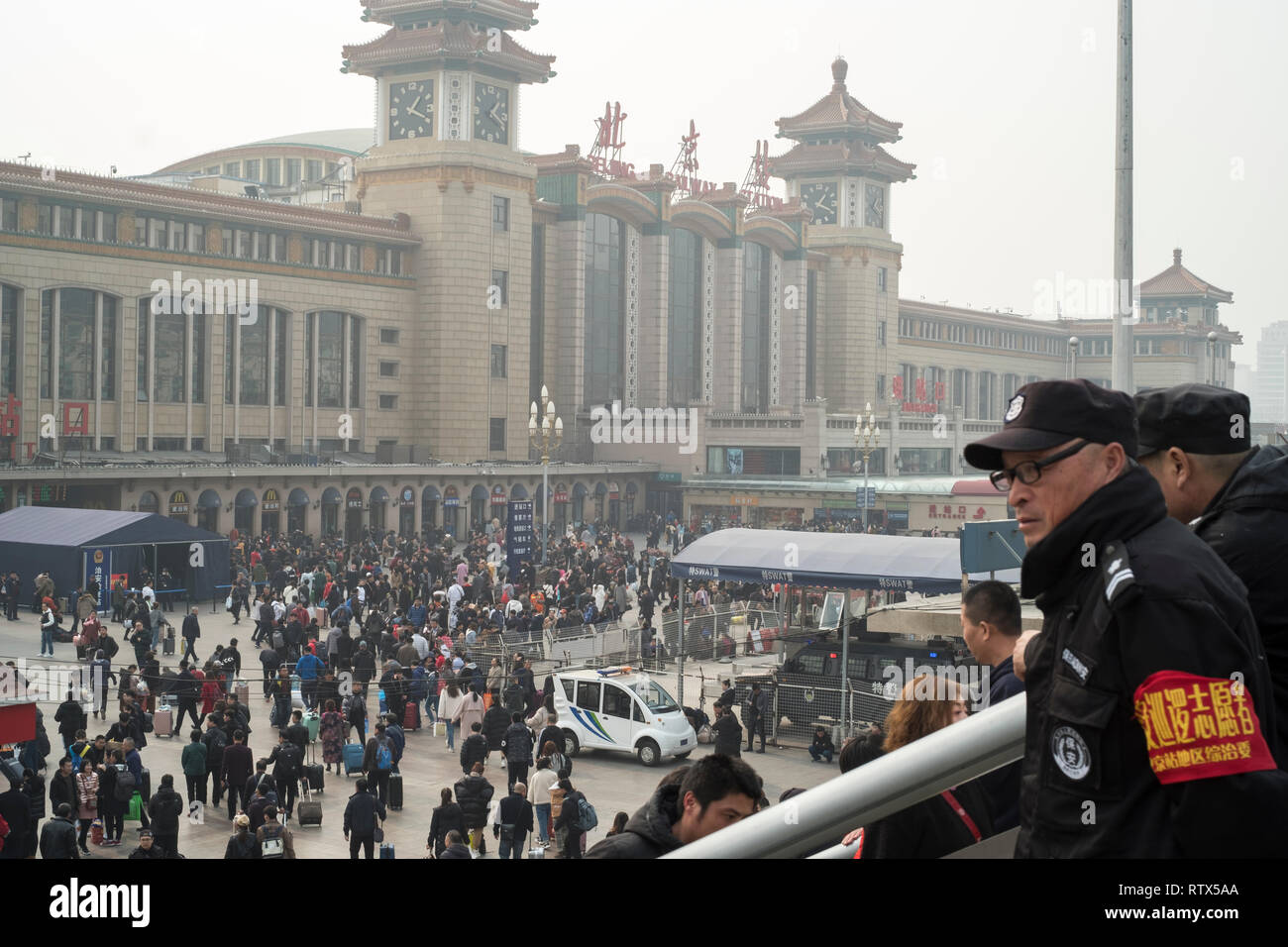 Deux hommes sécurité regarder la foule dans la gare de Pékin. La Chine interdit l'achat de 23 millions de billets de voyage dans le cadre du système "social credit" 03-Mar-2019 Banque D'Images