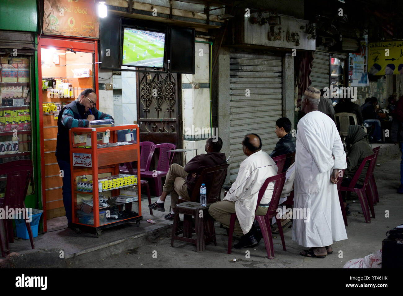 Groupe d'hommes regarder le football dans une rue du Caire Banque D'Images