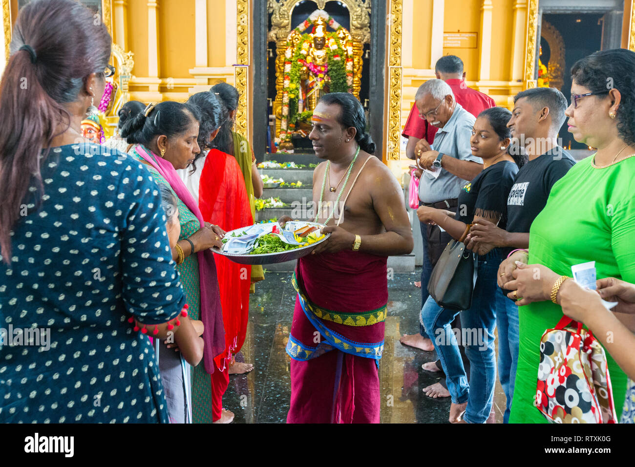 Prêtre hindou recevant des dons en face de Sri Perumal Venkatesha culte, Kuil Sri Krishna Temple Hindou, Kuala Lumpur, Malaisie. Banque D'Images