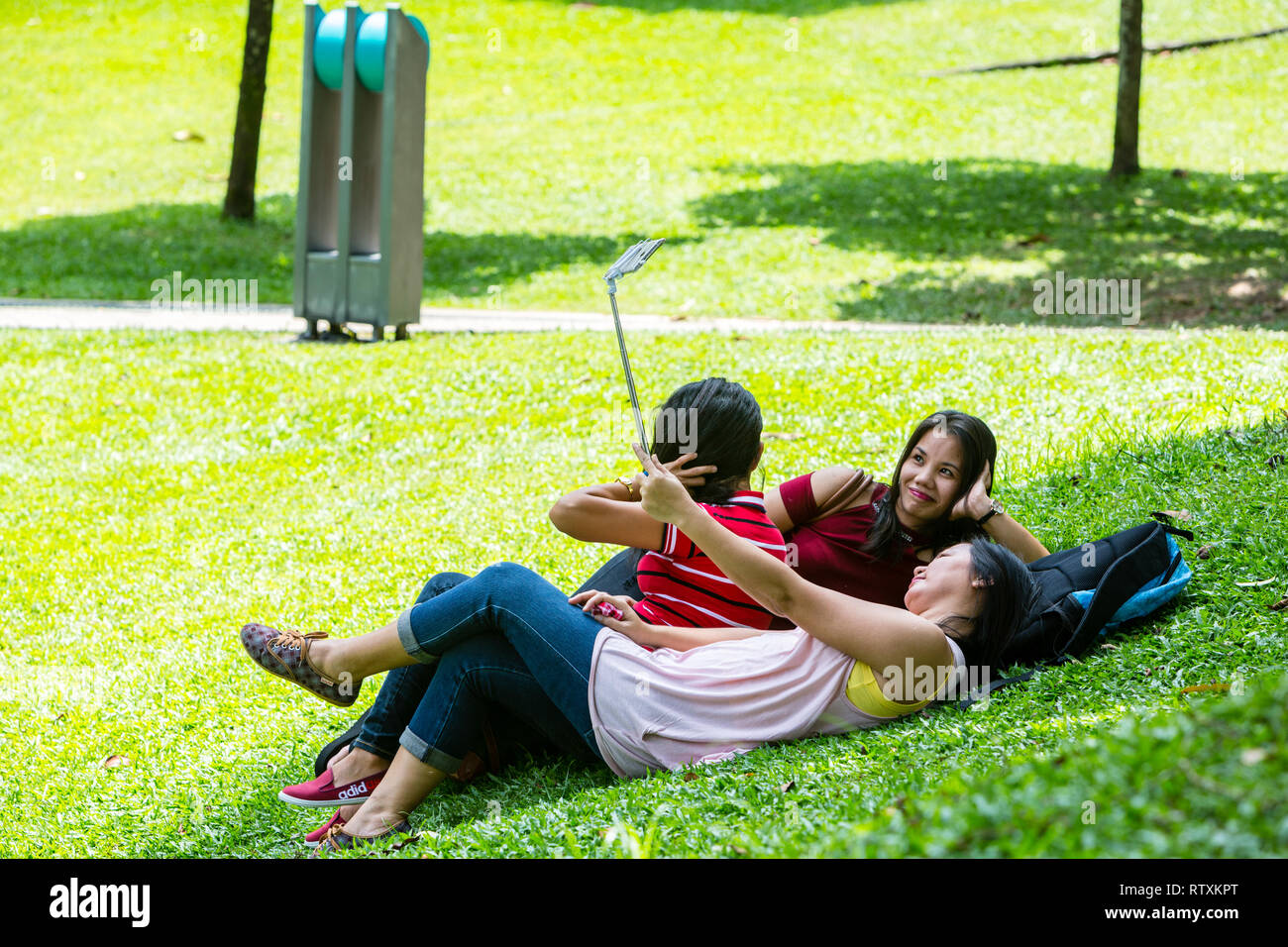 Les Malaisiennes se détendre, faire un parc KLCC à Selfies, Kuala Lumpur, Malaisie. Banque D'Images