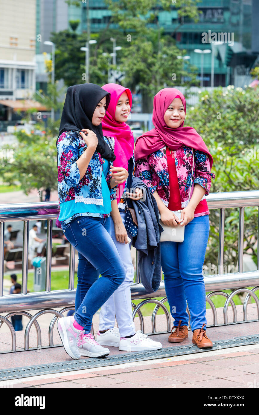 Les jeunes femmes malaisiennes qui pose pour une photo, le parc KLCC, Kuala Lumpur, Malaisie. Banque D'Images