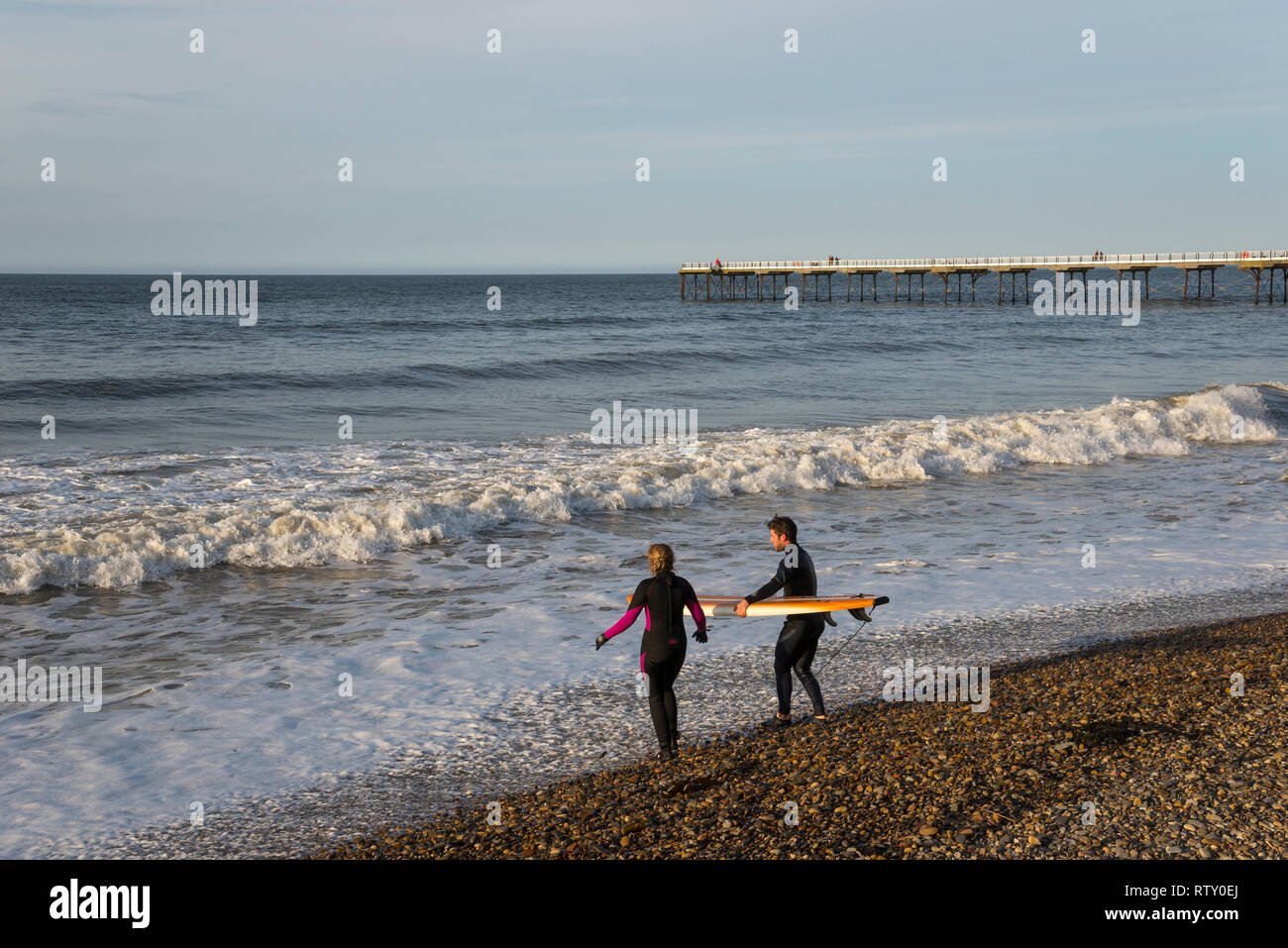 Deux jeunes surfeurs la position des vagues à Sawai madhopur, North Yorkshire, Angleterre. Banque D'Images